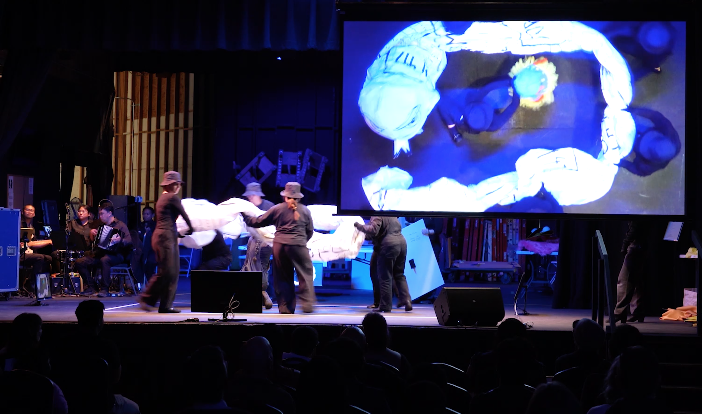 Audience view of the stage and video projection screen