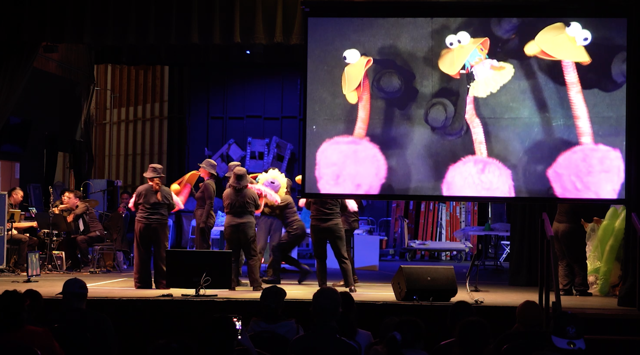 Audience view of the stage and video projection screen