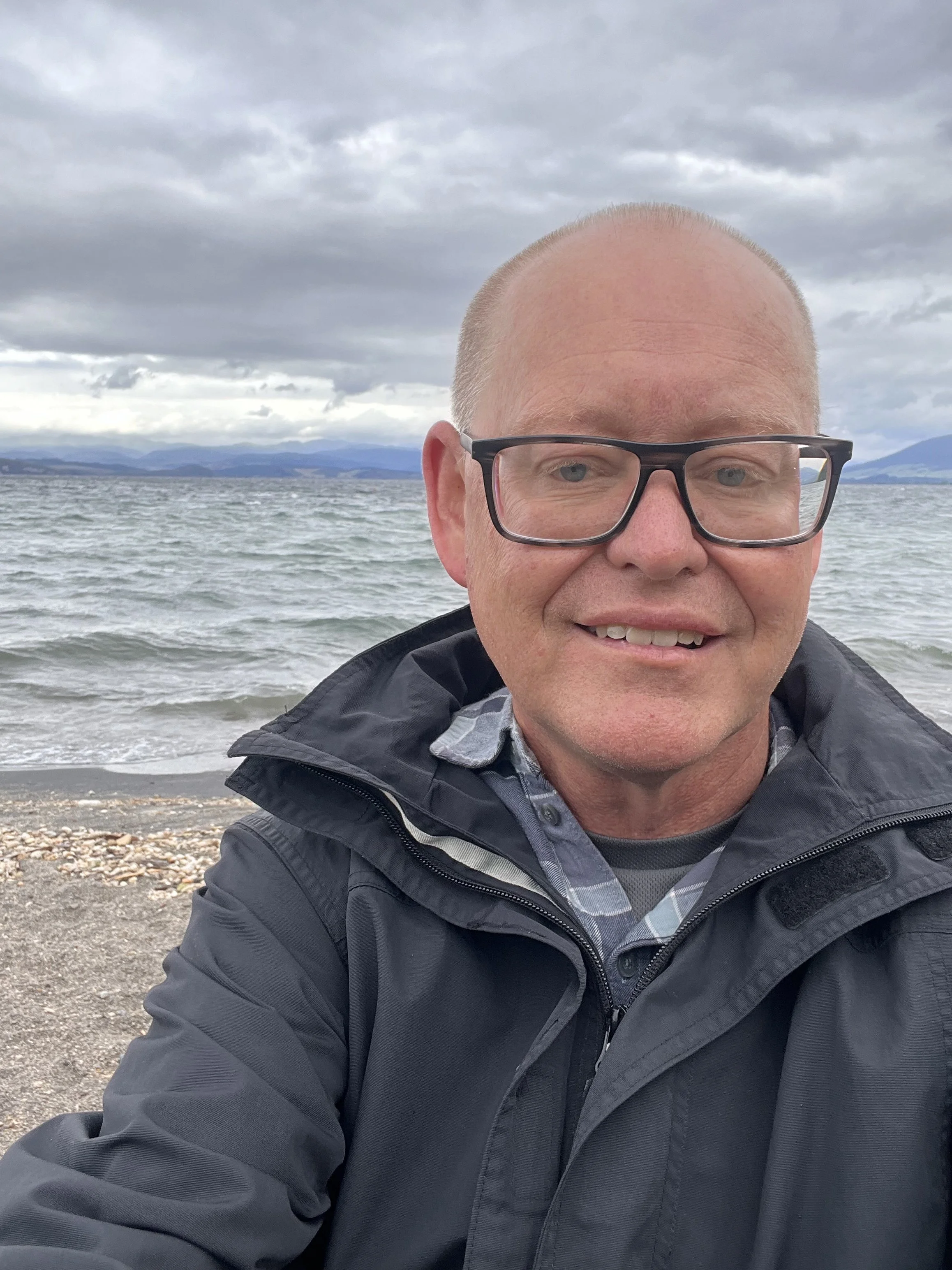 Minister smiling at the camera with Lake Taupo in the background.