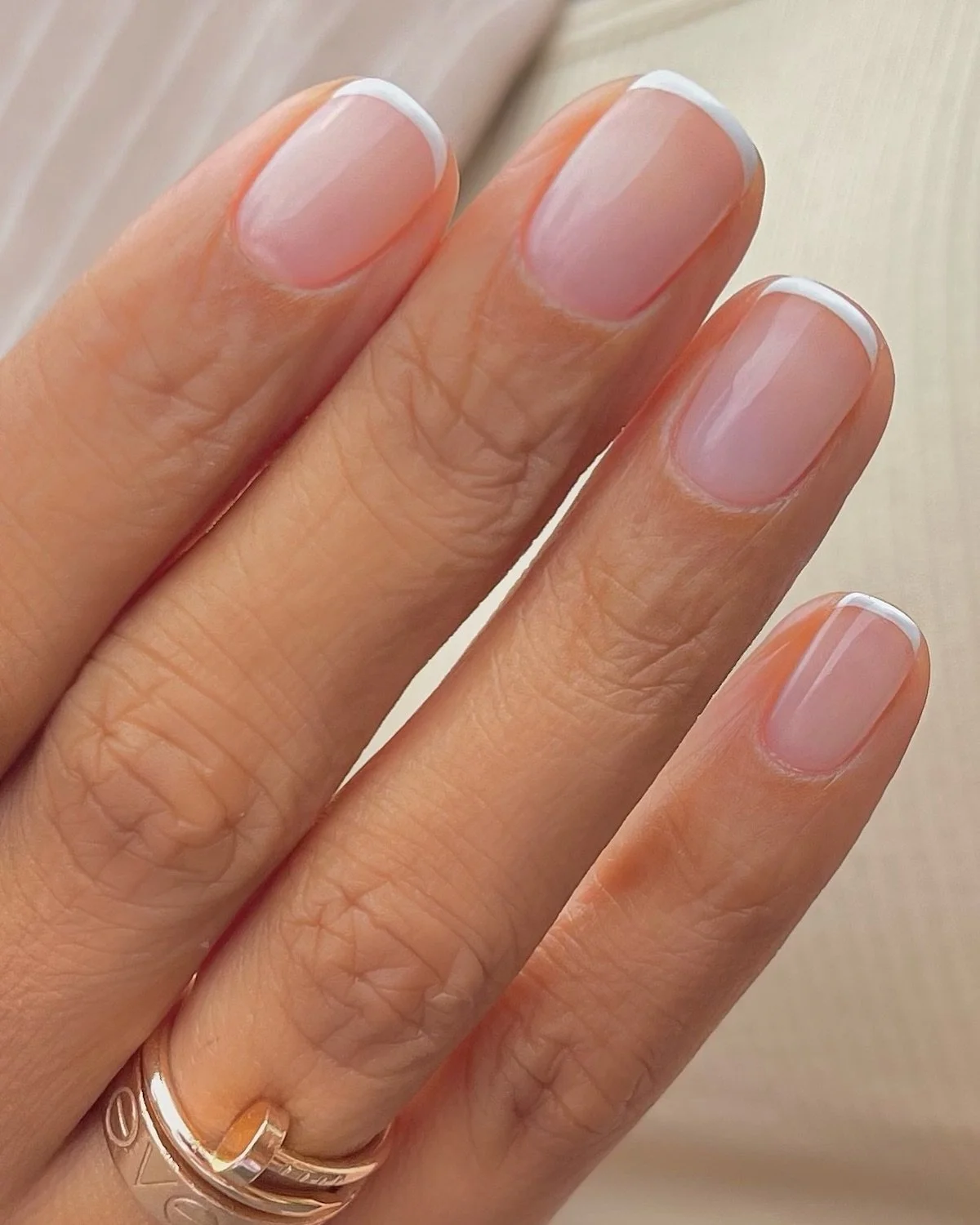 Micro French tip nails with thin clean lines created using Russian manicure technique in NYC