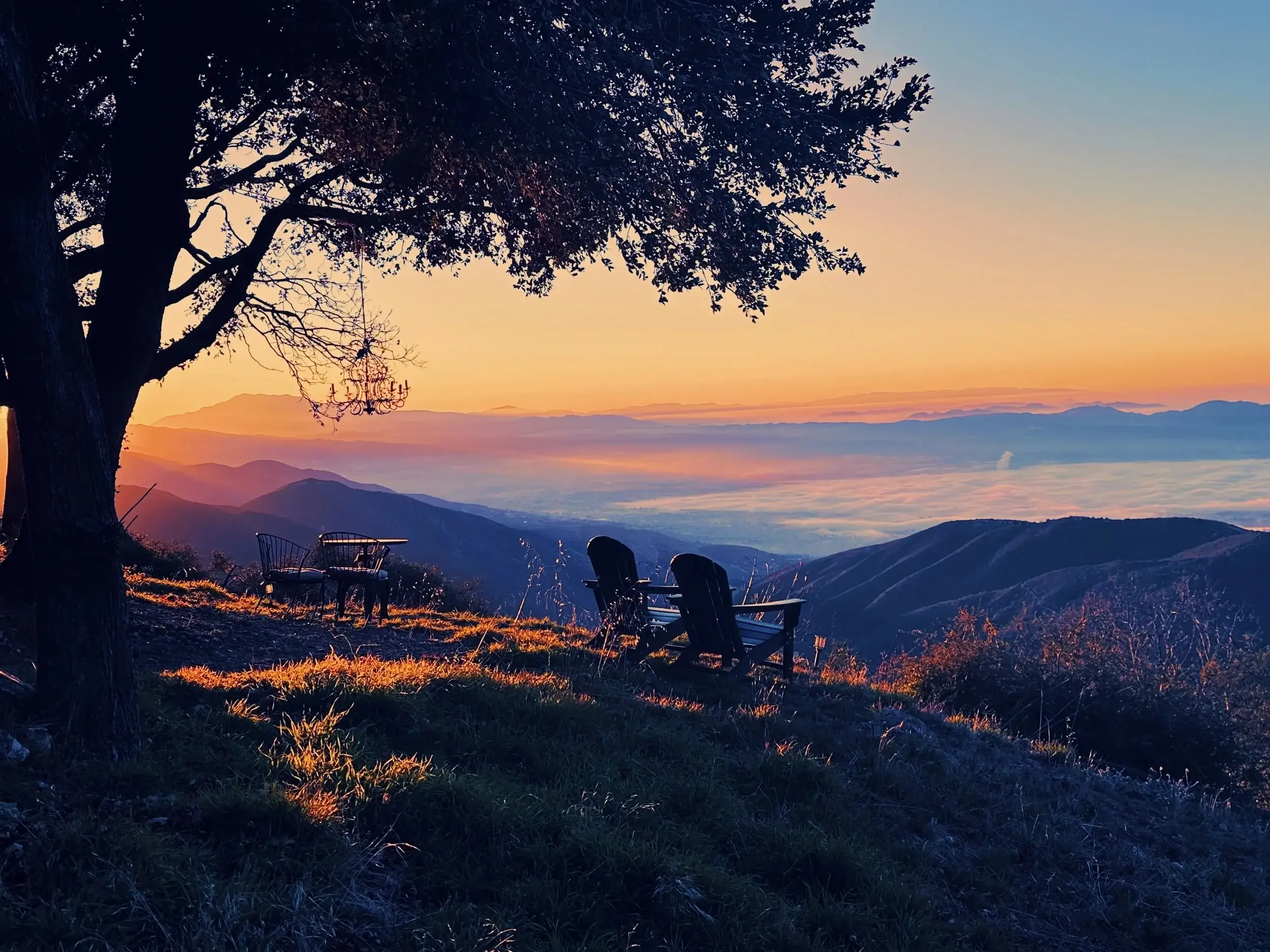 Breathtaking sunrise over the San Bernardino Mountains and shimmering city lights, viewed from the scenic overlook at Holly Hill Chalet in Crestline, California. This 100-mile view is a premier feature of our mountain retreat and film location.
