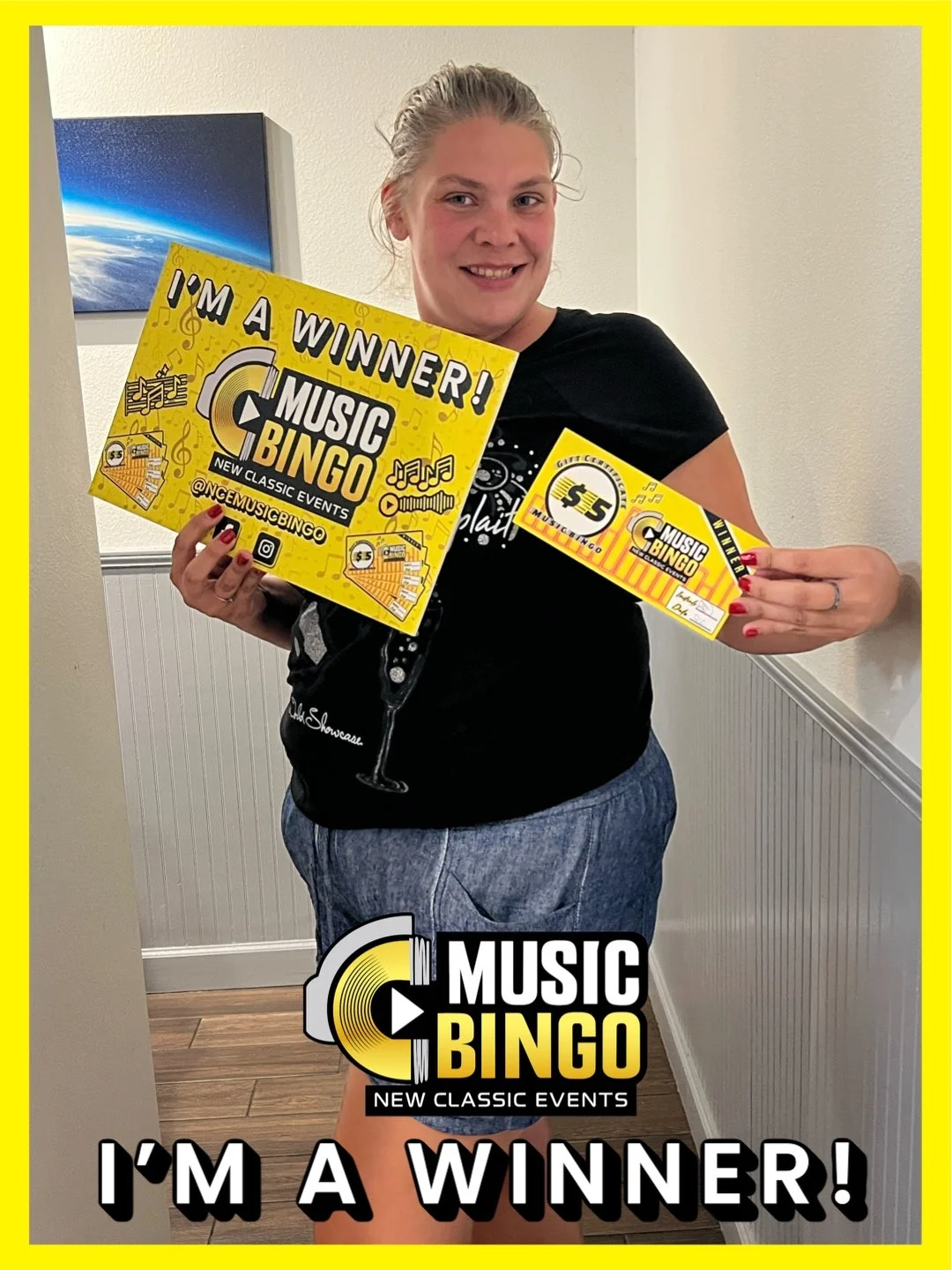 Woman holding a yellow music bingo winner poster and tickets, smiling at the camera, standing in a room with a wall art of space in the background.