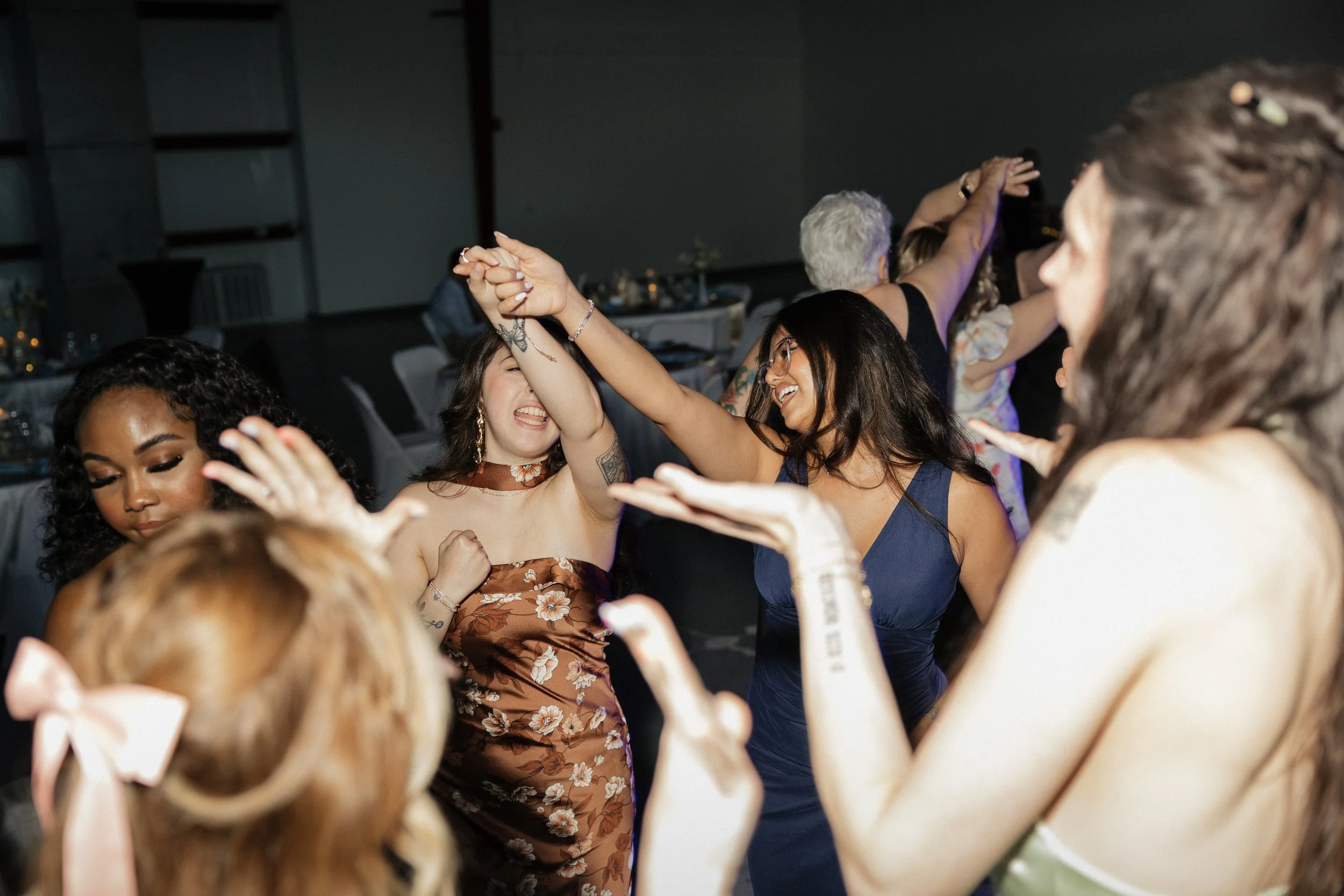 People dancing and enjoying themselves at a lively indoor celebration or party.