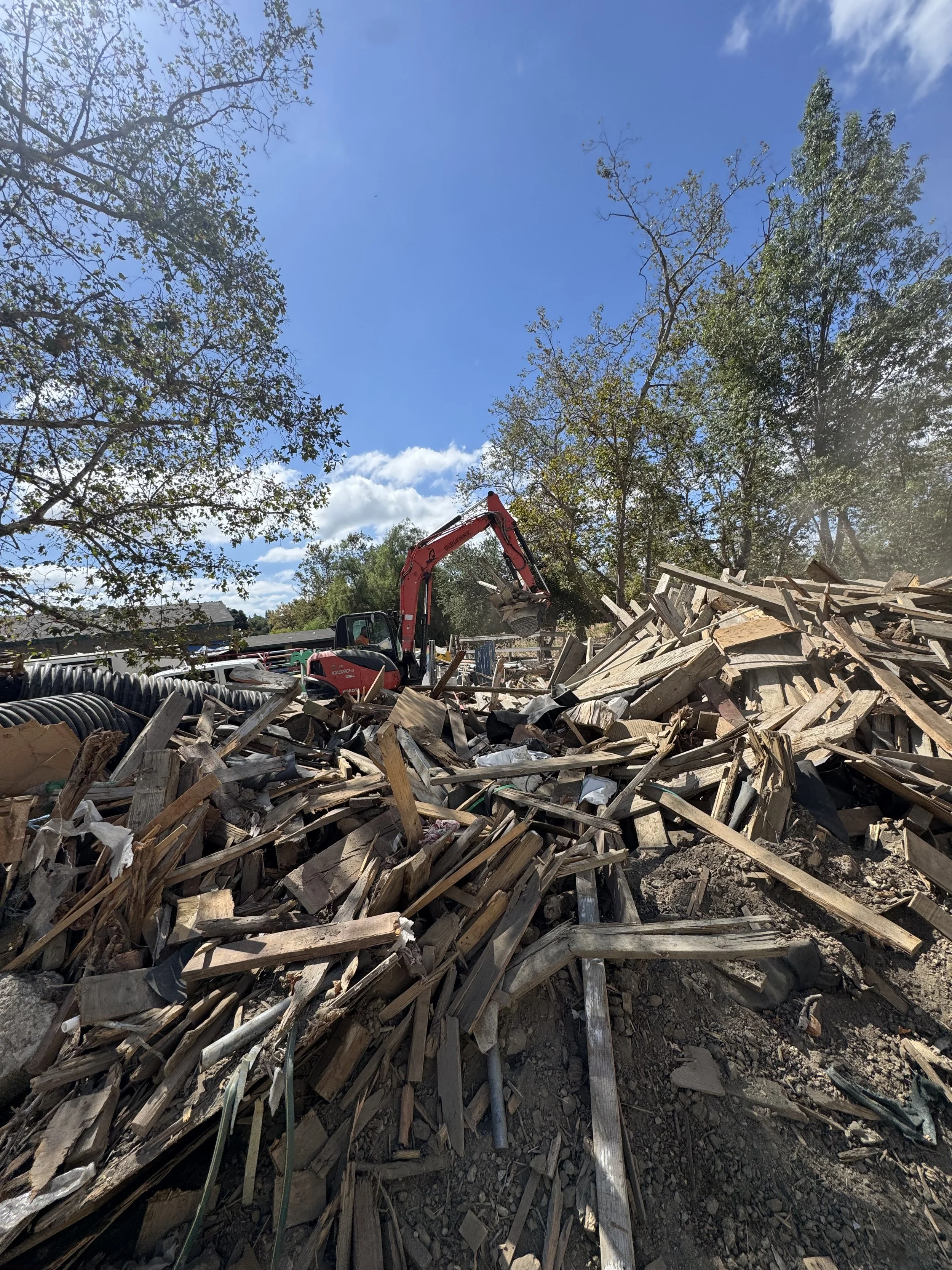 Construction or demolition site with a large excavator cleaning and clearing 