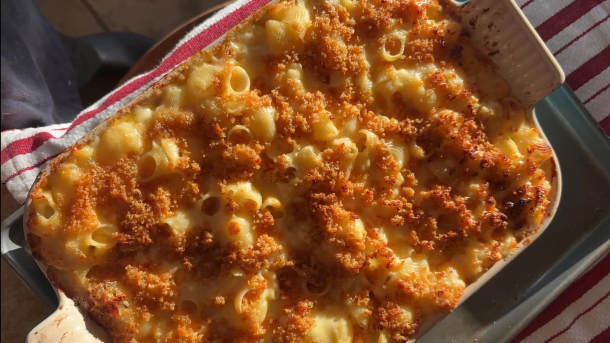 Baked macaroni and cheese with a golden breadcrumb topping in a casserole dish.