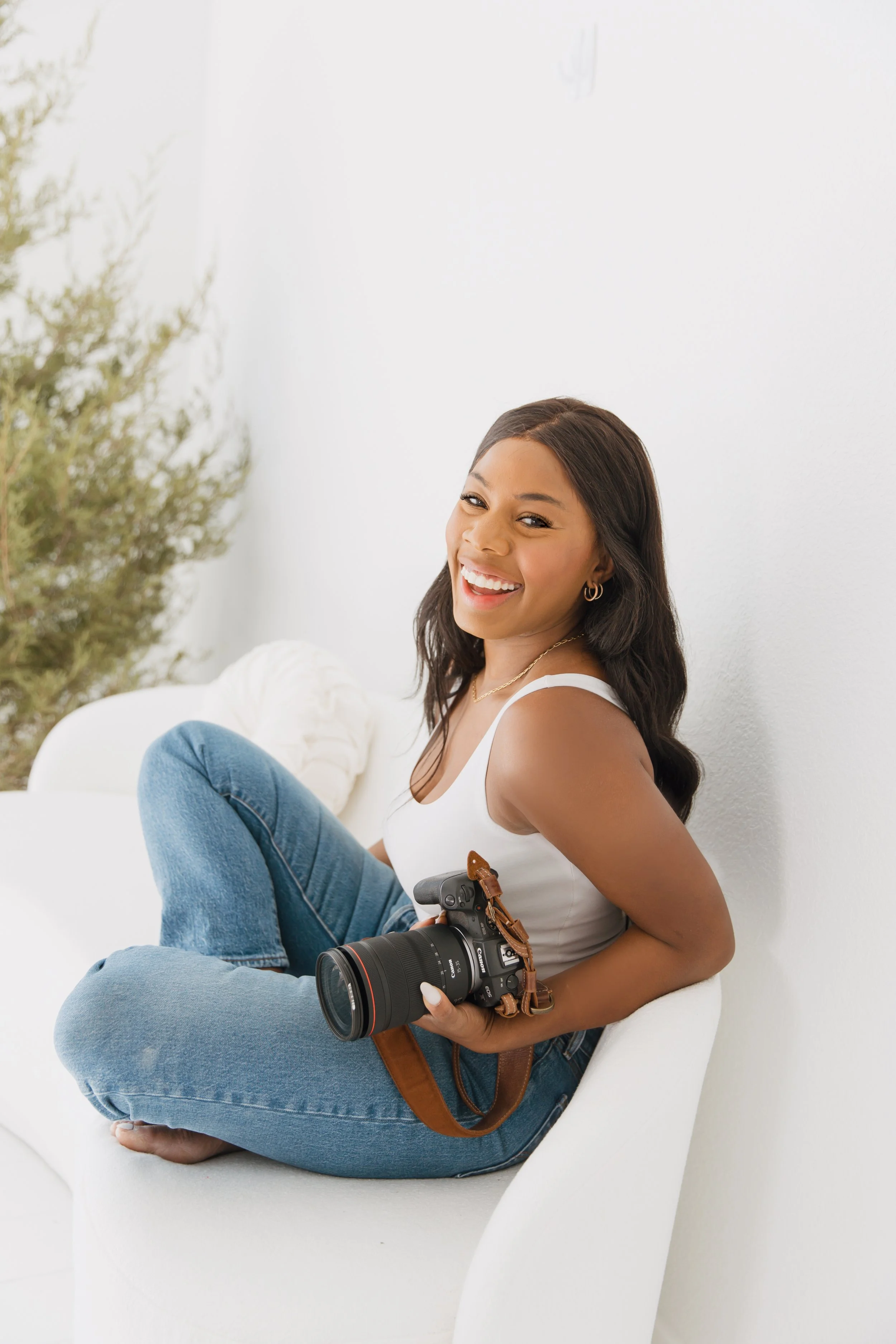 Personal branding portrait of a photographer seated with her camera.