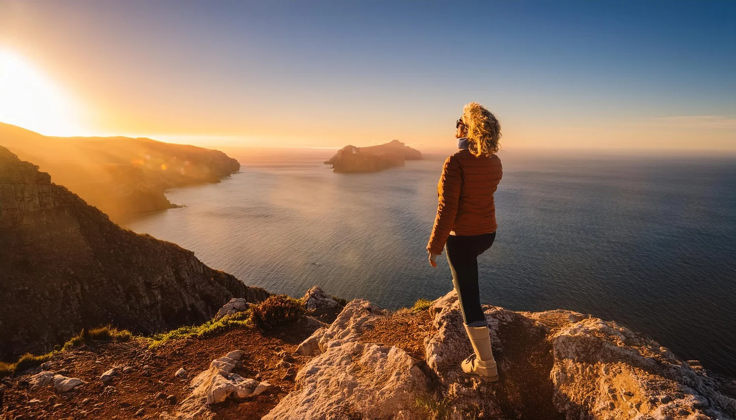 A woman standing calmly on a clifftop, looking out with hope
