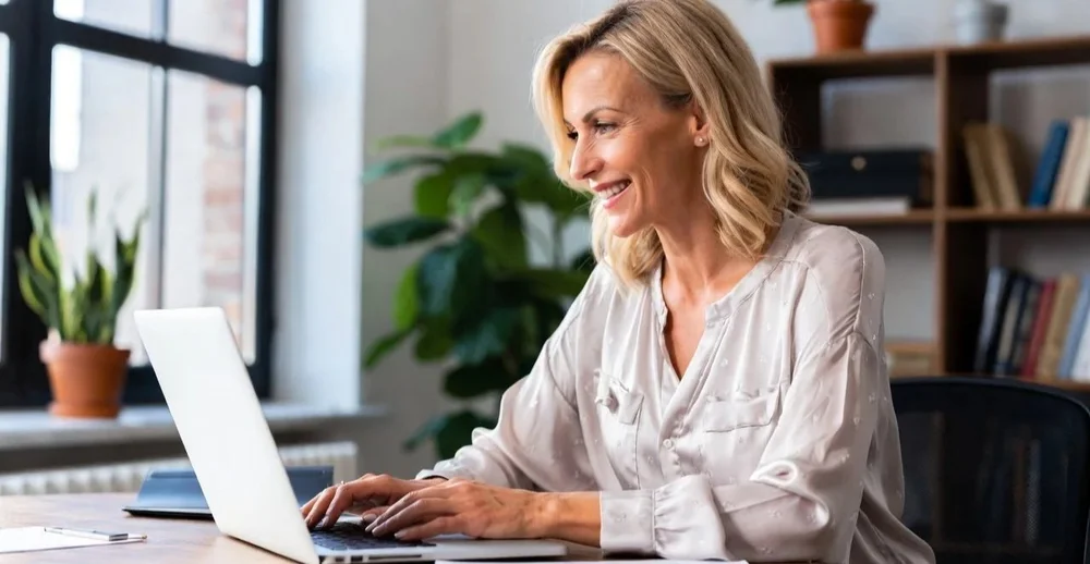 A woman at a laptop, ready for an online therapy session from home