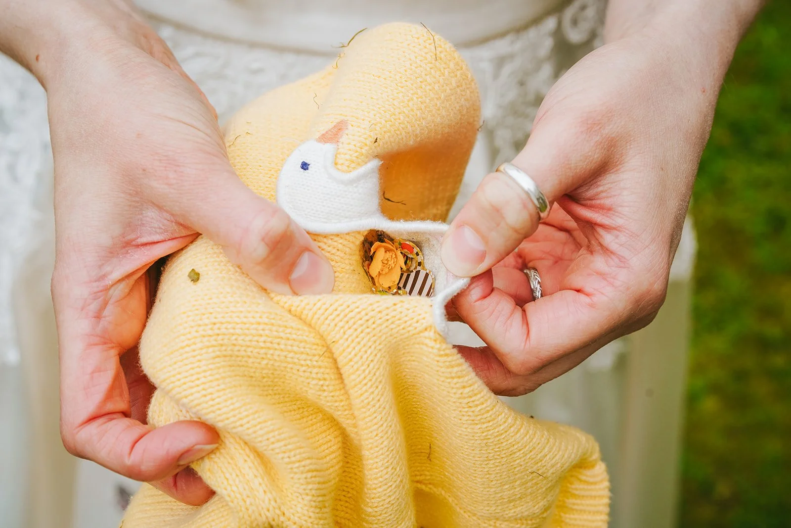 bride holds out yellow duck cardigan by endeavour woodland weddings photographer david lefebvre in buckinghamshire