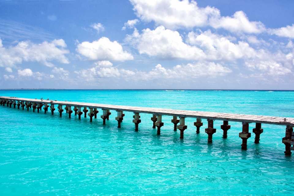 A wooden jetty extends into the Caribbean Sea at Cancun