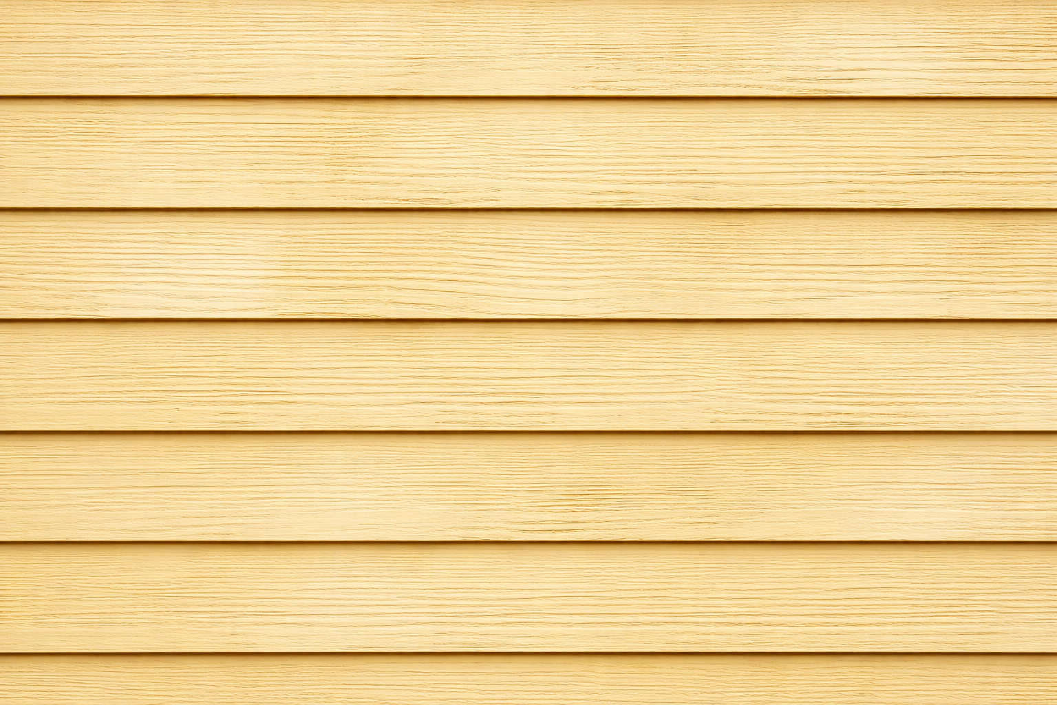 Close-up of horizontal wooden siding painted in light yellow