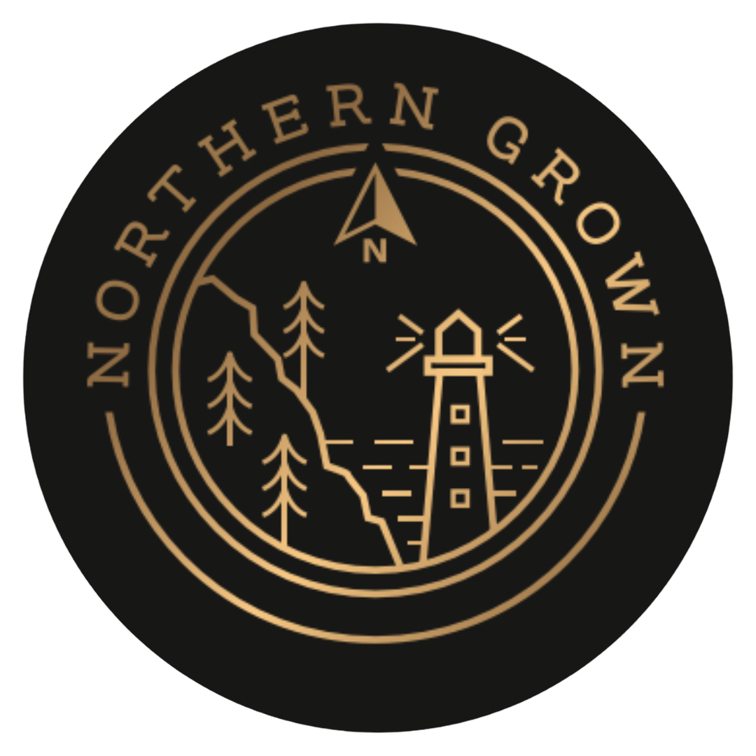 Logo of the Northern Ground with a lighthouse, trees, and a mountain, featuring a compass point at the top.