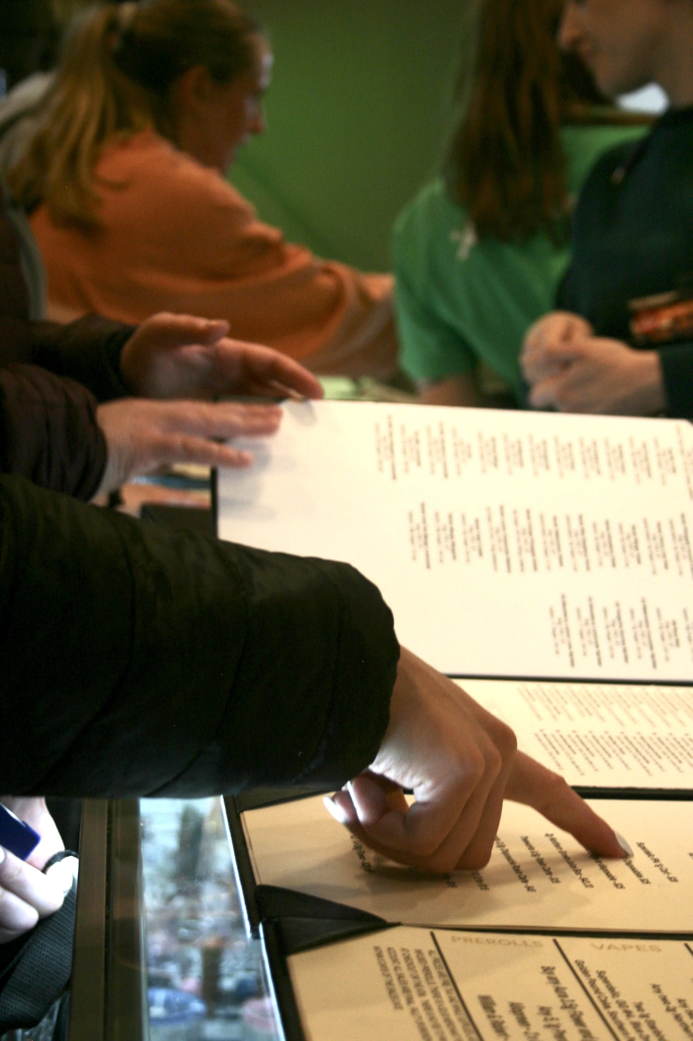 People holding menus at a restaurant table.