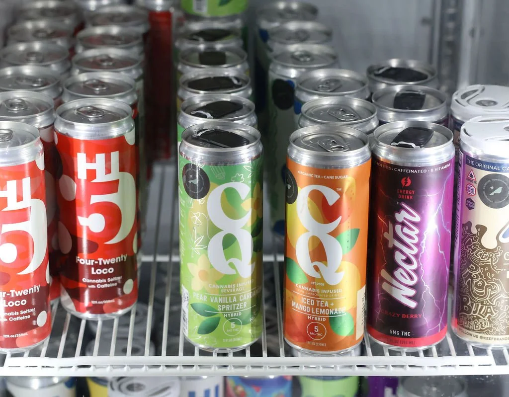 Assorted flavored cannabis-infused energy drinks and seltzers on store shelf.