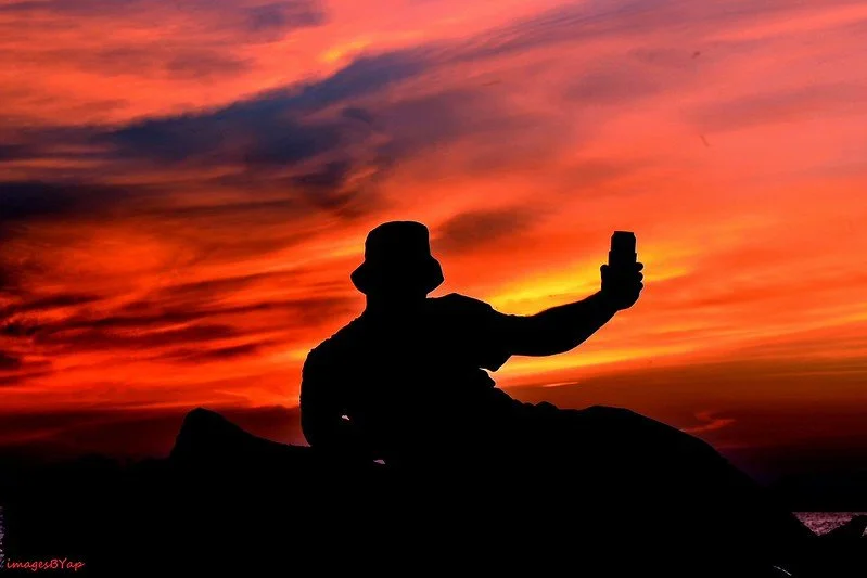 person toasting at sunset