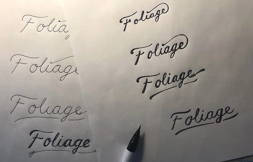 Hand-drawn lettering sketches exploring custom typography concepts during early brand identity development