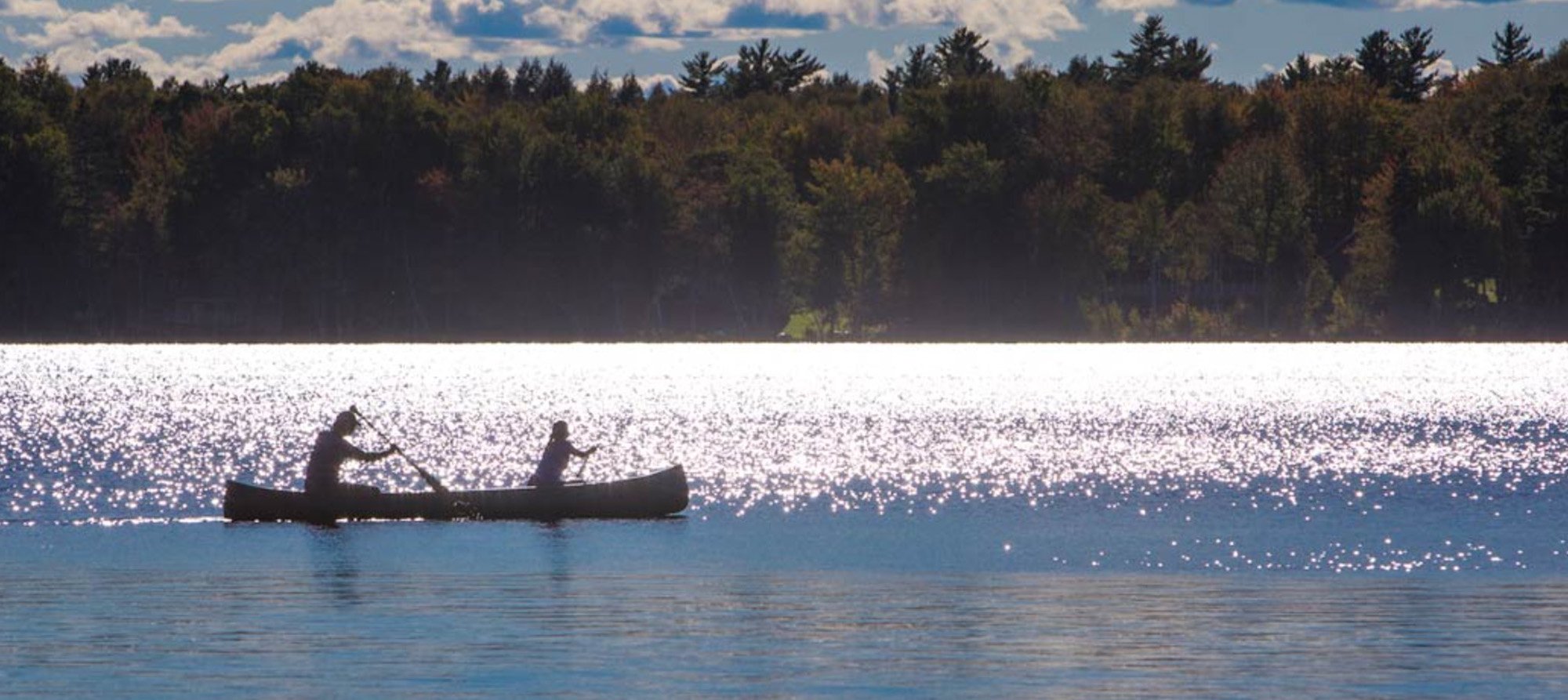 Canoe on open water using wooden paddles, reflecting traditional outdoor use and craftsmanship