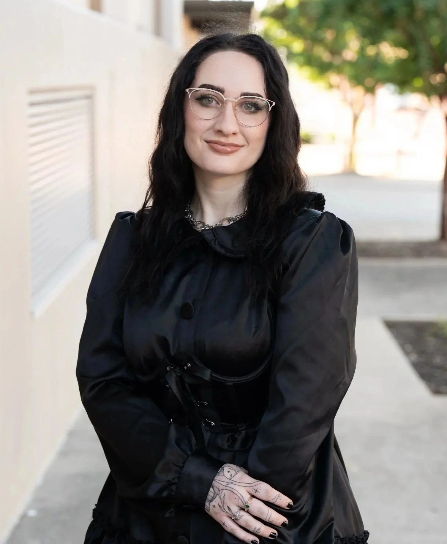 Smiling person with glasses, black dress