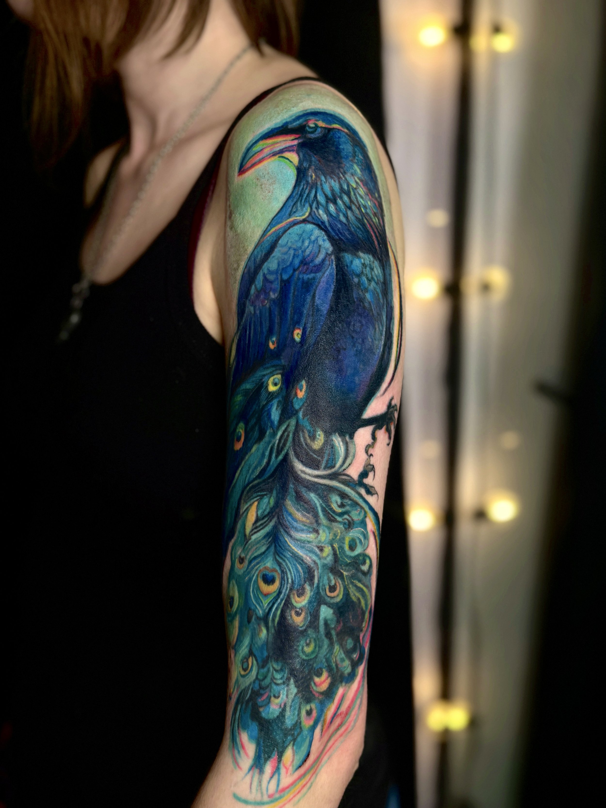 Crow with peacock feathers illustrative tattoo 