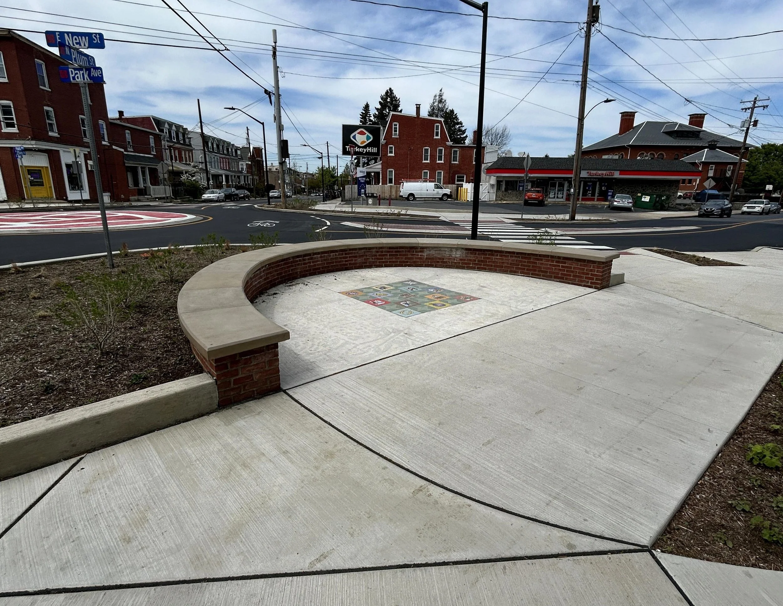 Radius seat wall. Curb, sidewalk, ADA, light bases, cheekwalls. Plum St. roundabout