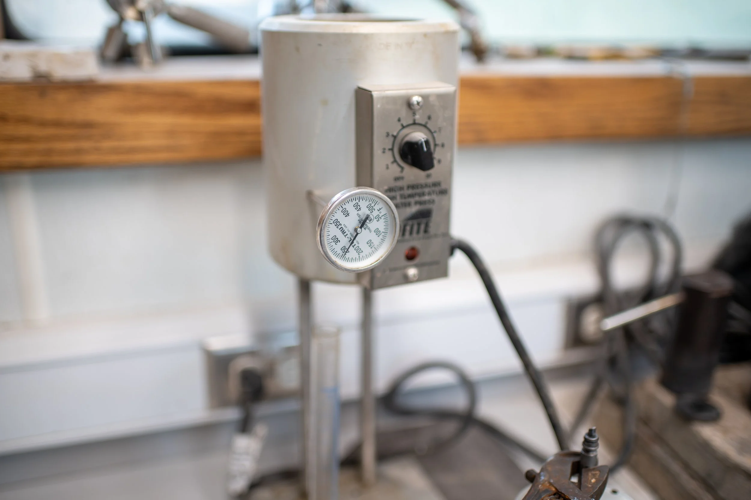 Industrial equipment with a temperature gauge and a control dial mounted on a metallic surface.