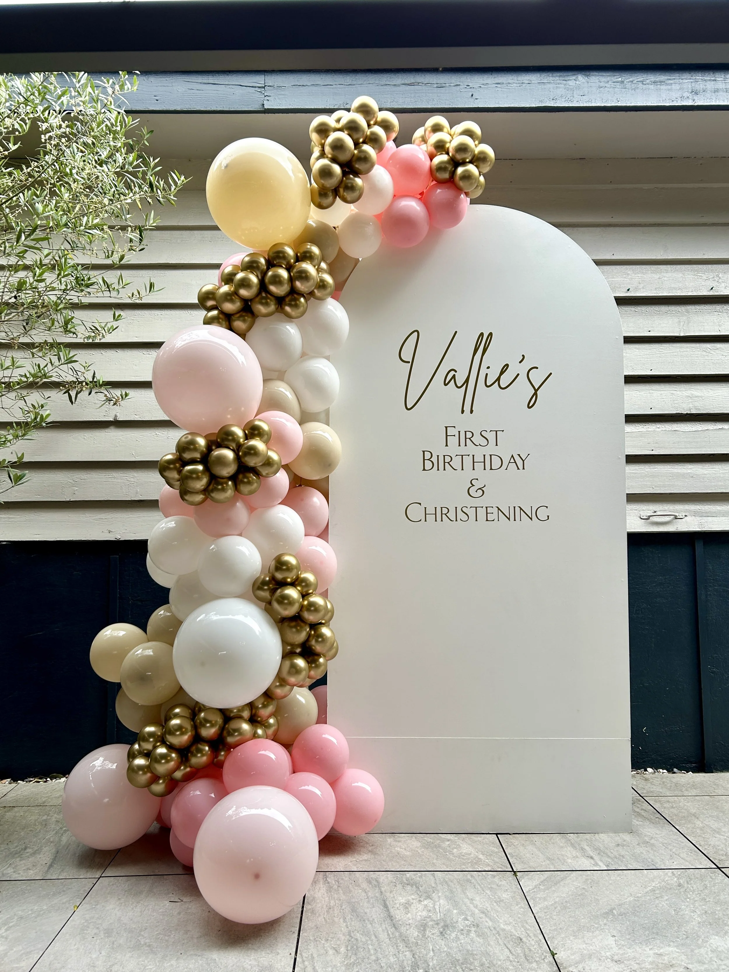 white sailboard with cream, pink and gold balloon garland