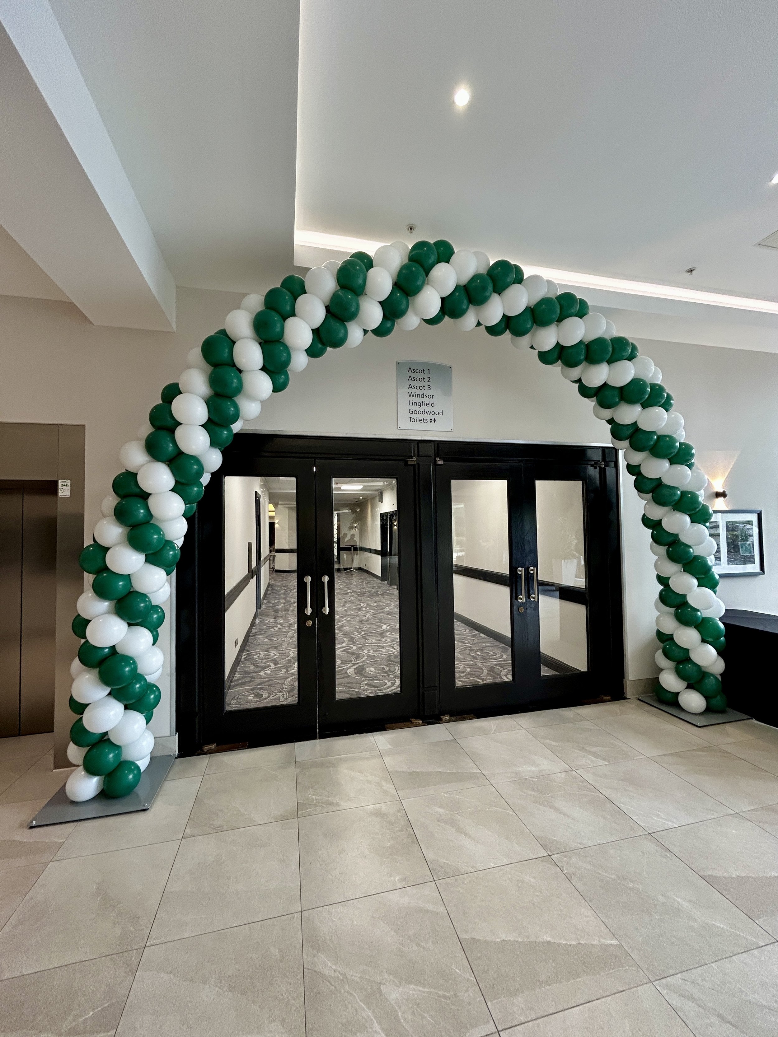 green and white balloon arch for a corporate event at the hilton hotel in gatwick 