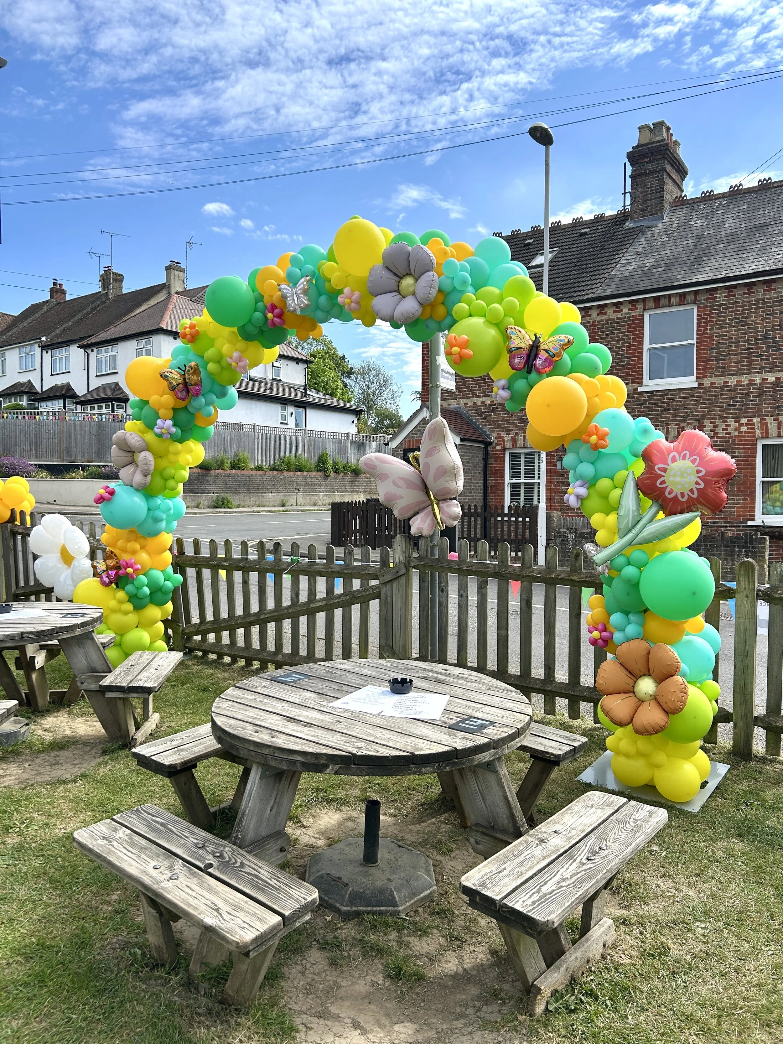 Spring themed balloon arch for a pub in east grinstead using yellow and green balloons with butterflies and flowers