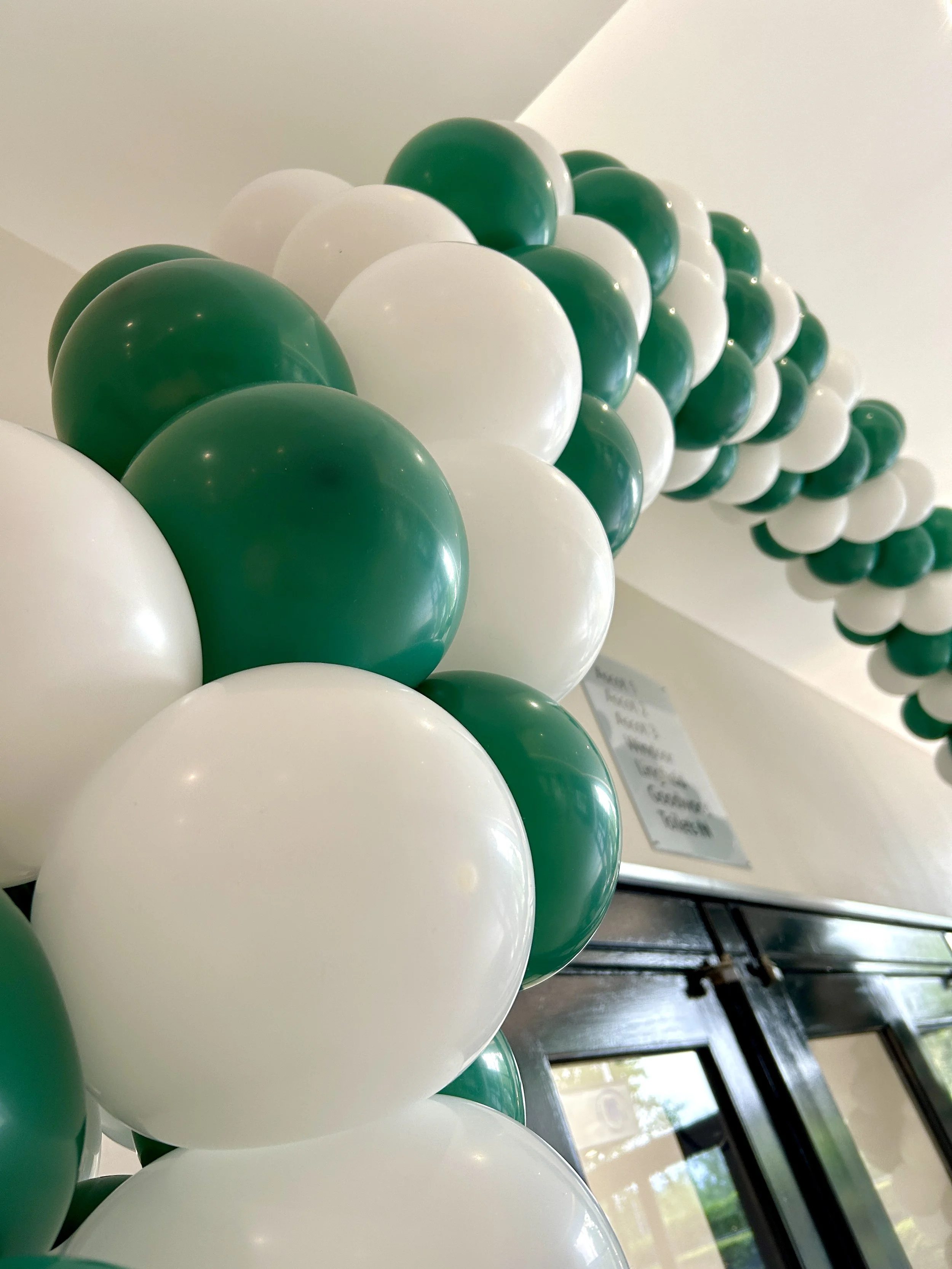 green and white balloon arch for a fitness company at a hotel in gatwick 