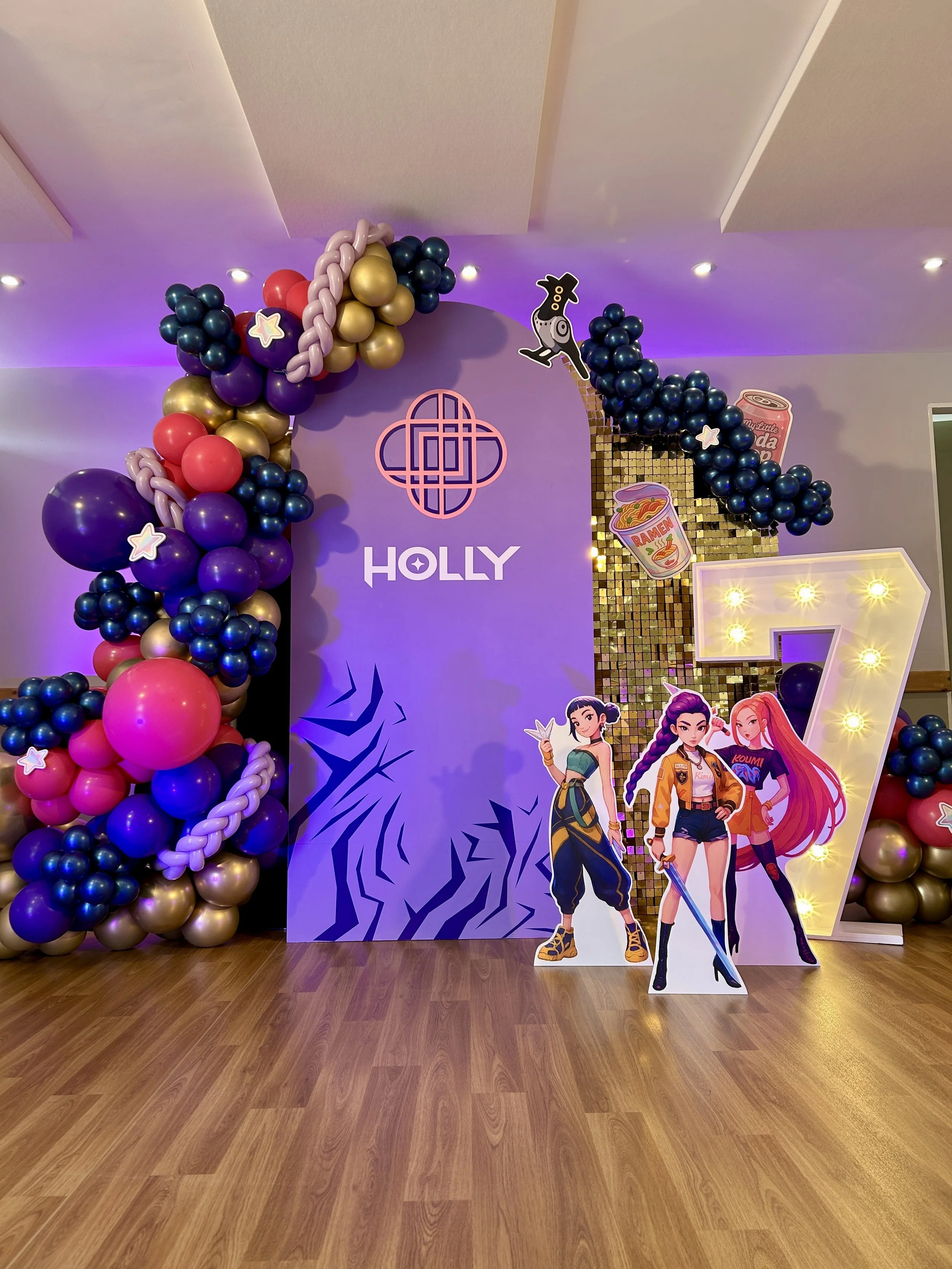 K pop themed sailboard with light up number 7 for a children's birthday party with gold purple and pink balloons and added cut outs