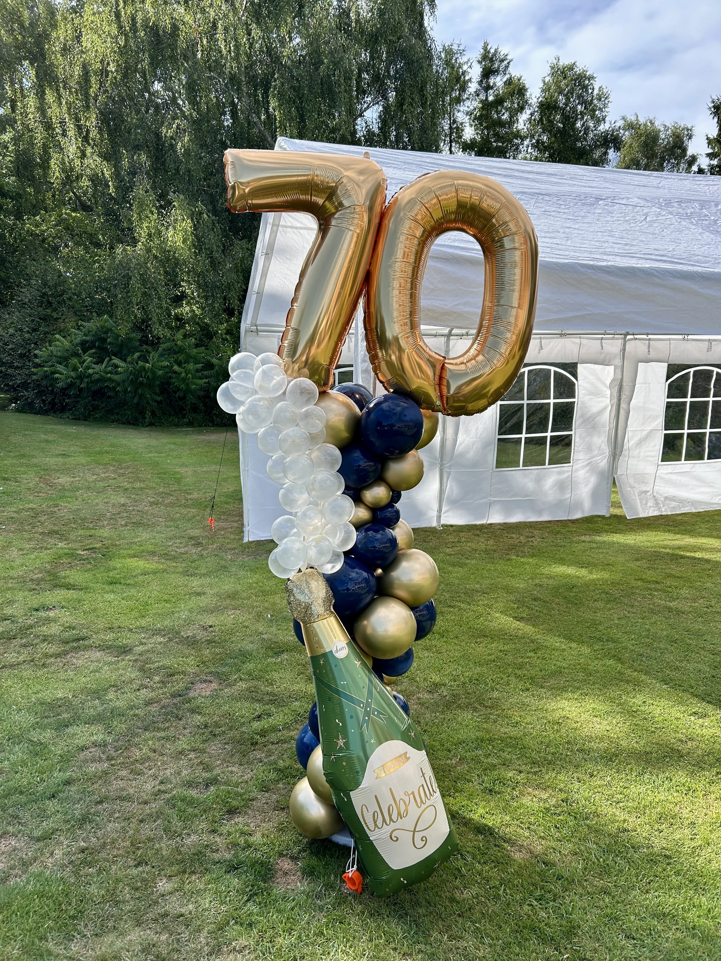 70th birthday balloon column with champagne bottle bubbles and 70 foil balloons
