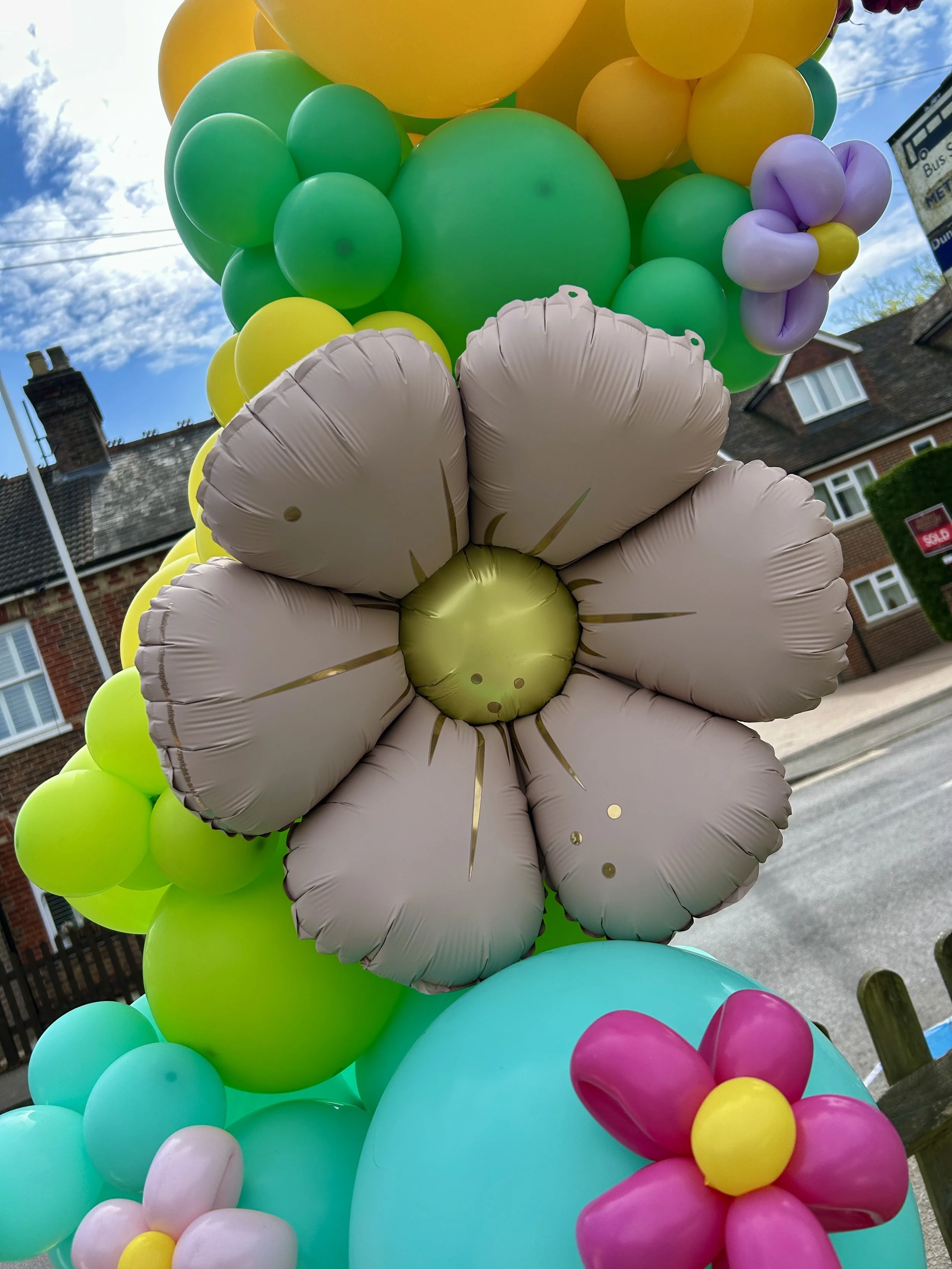 Large foil balloon flower on a spring themed balloon arch at the old runnings mill pub in east grinstead
