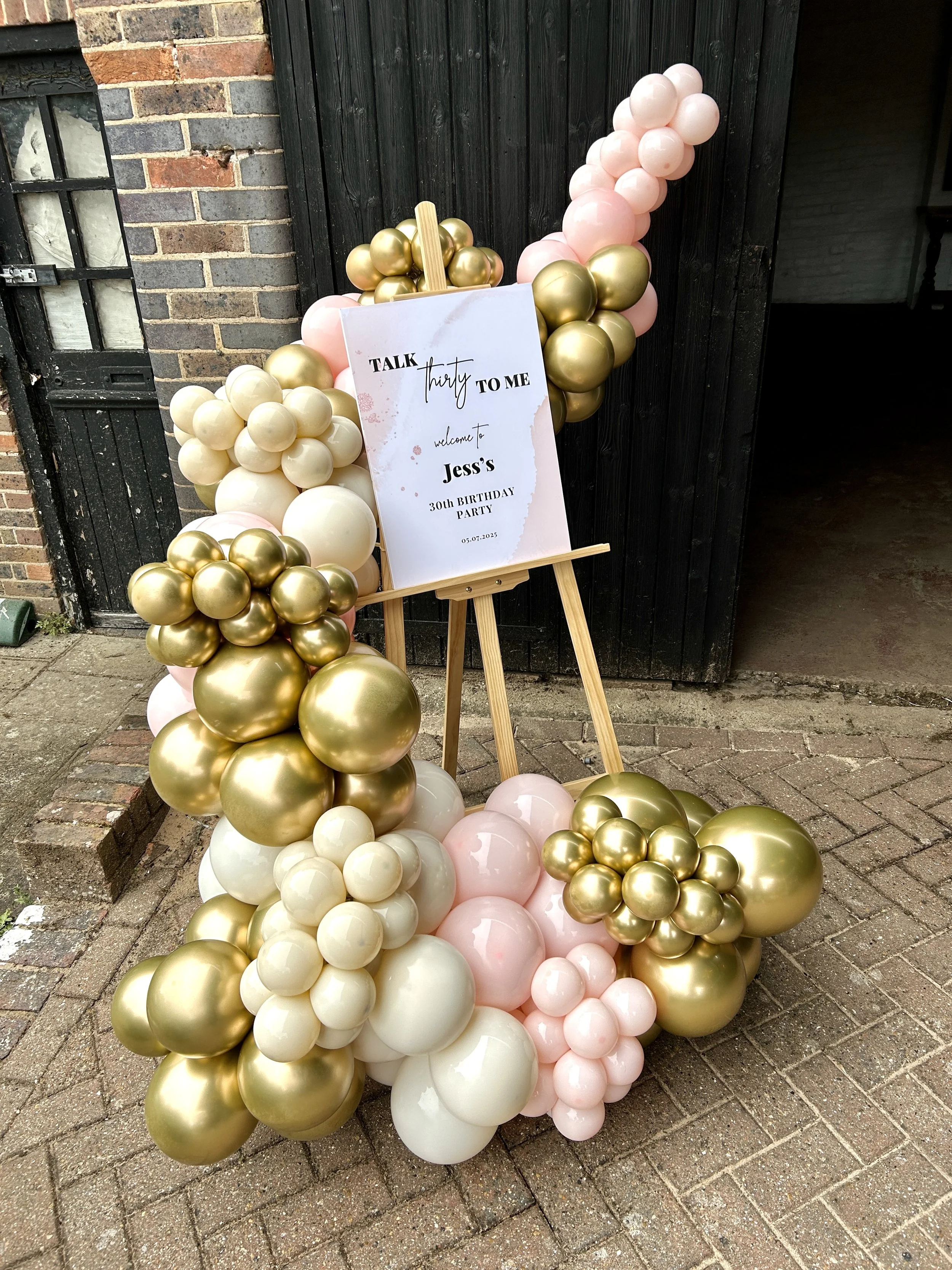 Easel with personalised board for a 30th birthday using gold beige and pink balloons at the dorset arms in east grinstead