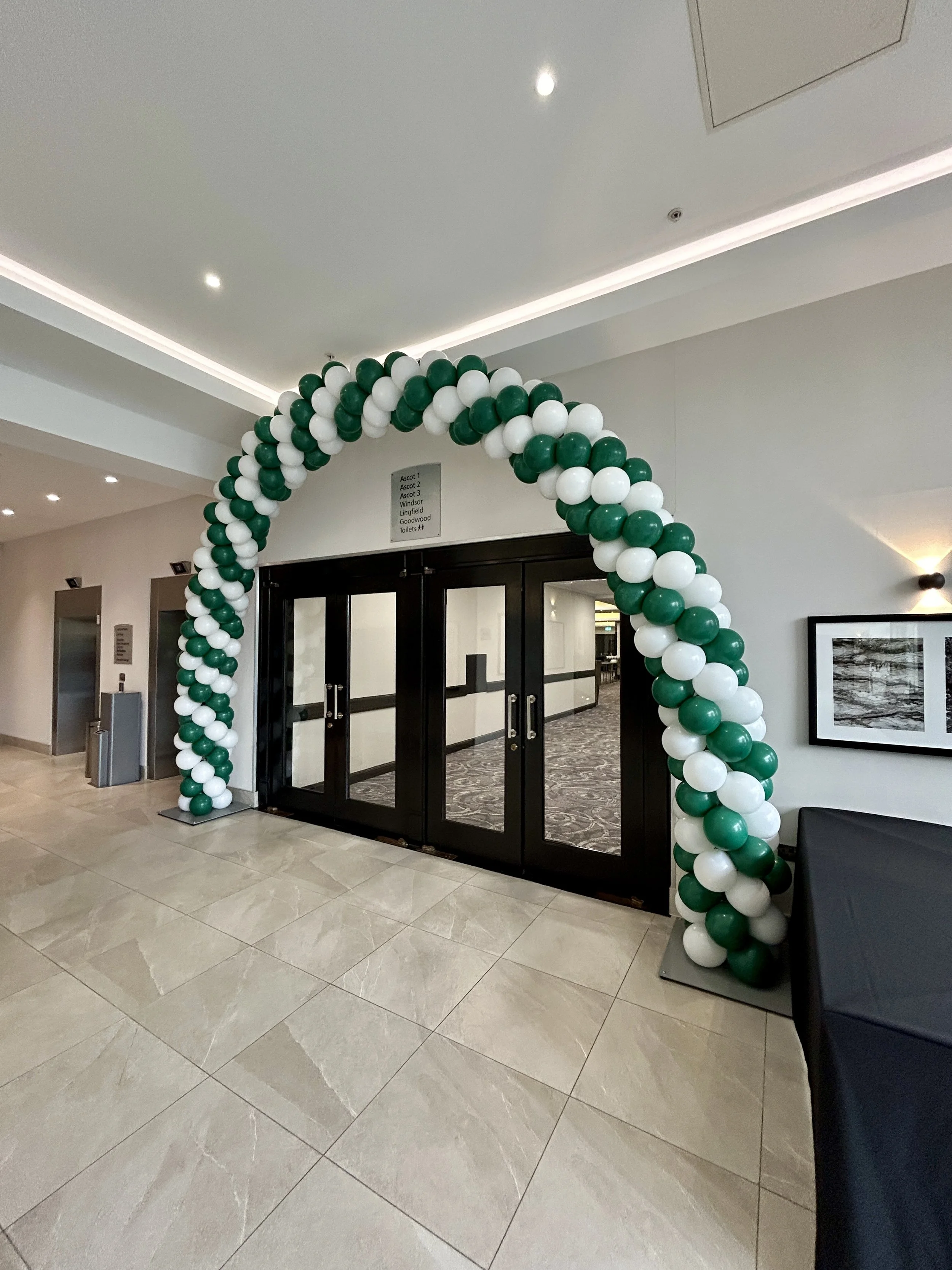 green and white balloon arch for a corporate event the hilton hotel in gatwick 