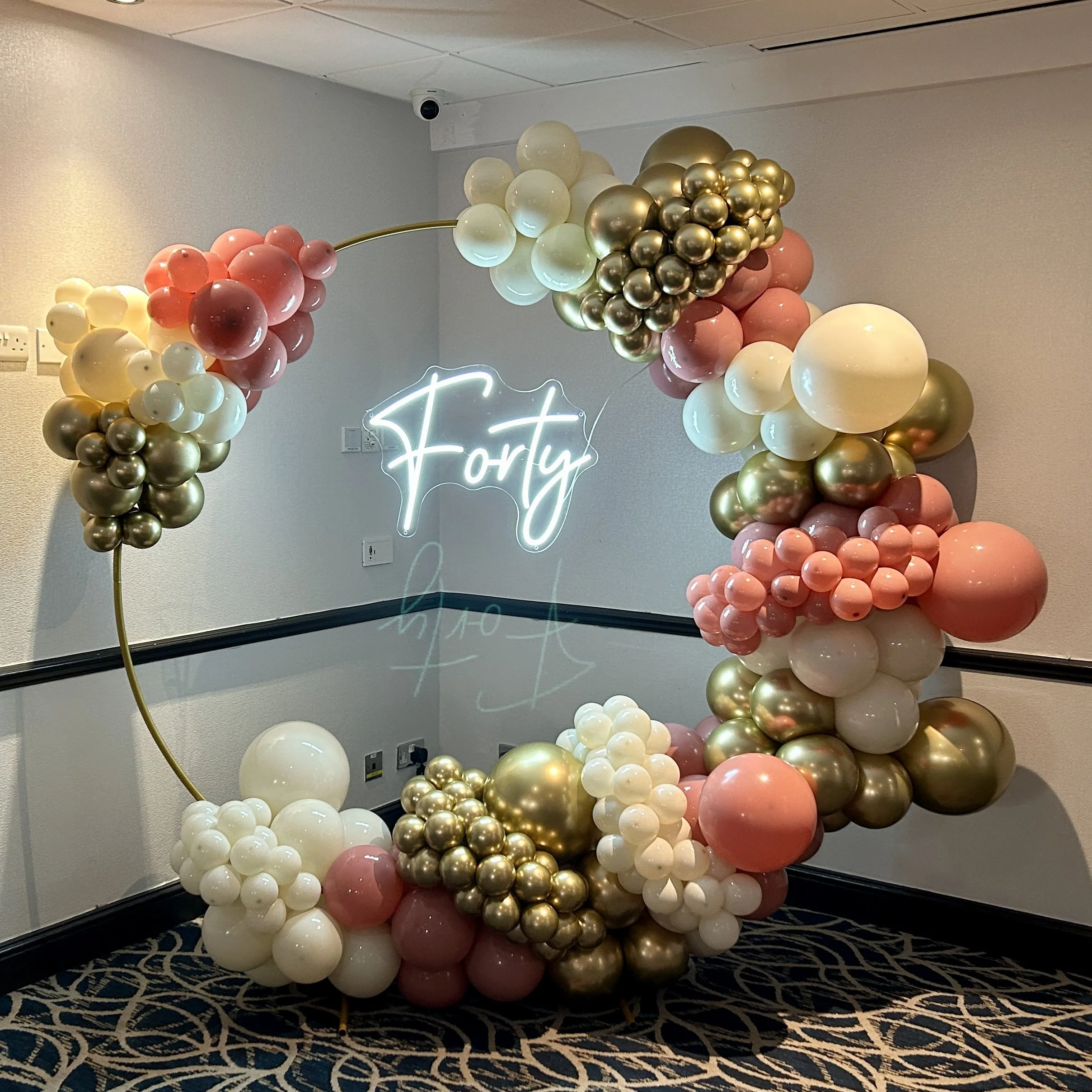ballon hoop using gold cream and pink balloons with a forty light up sign hanging in the  middle for a 40th birthday at the felbridge hotel in east grinstead