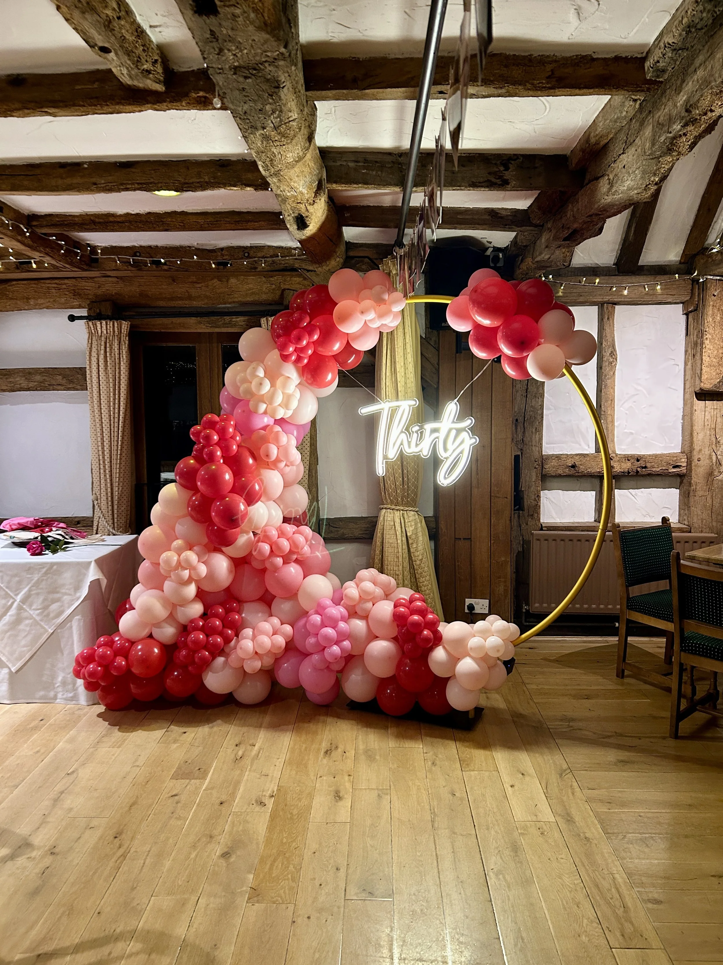 pink and red balloon hoop with thirty led sign in tunbridge wells