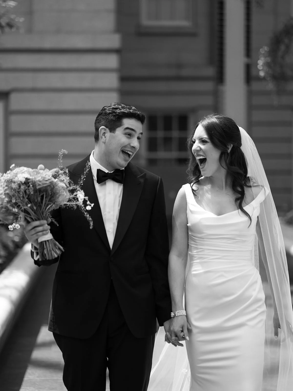 Laurie’s customers, Mariana and Carmen holding hands on a green lawn on their wedding day.