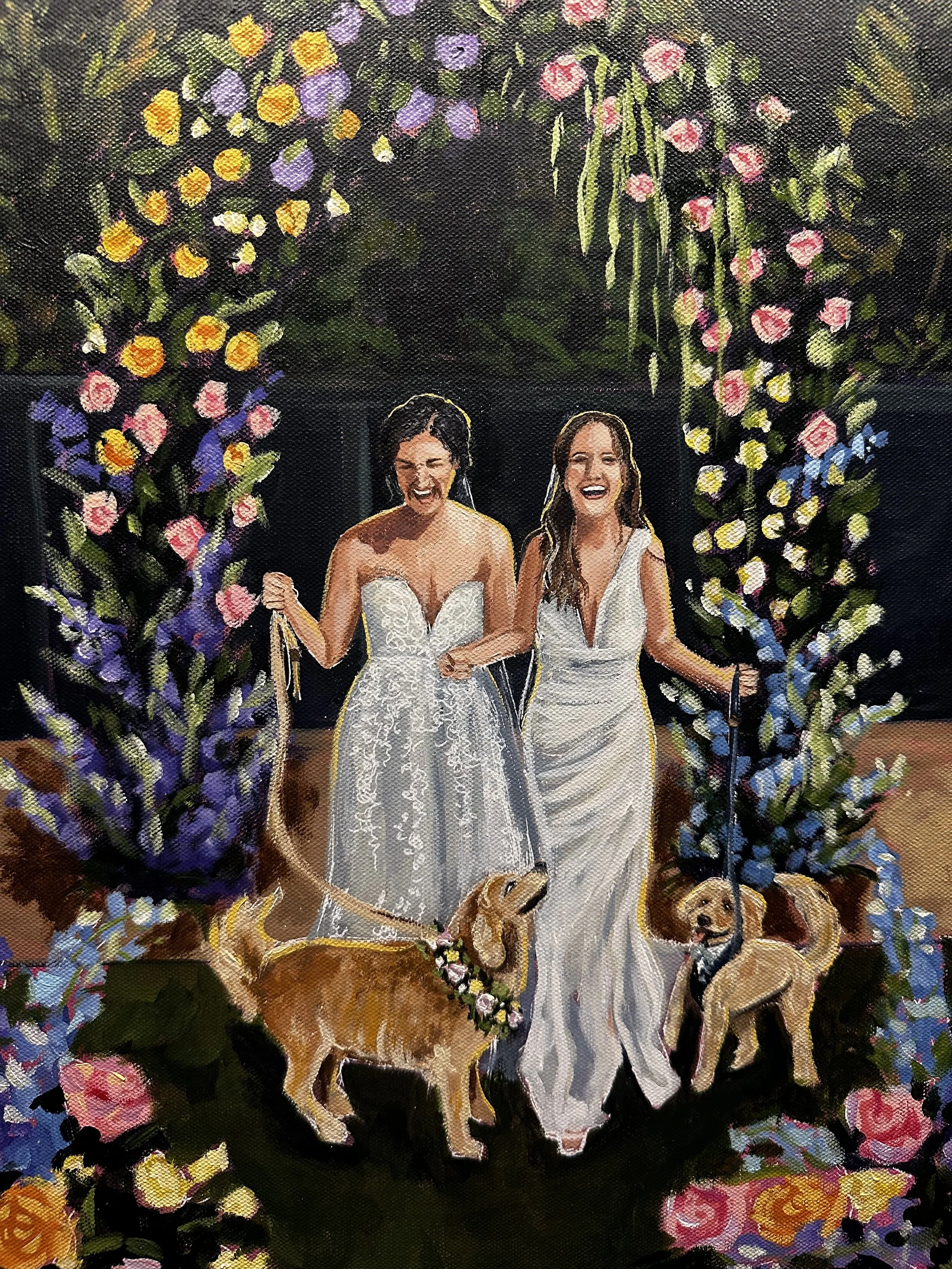 Two women in wedding dresses holding leashes of two golden retrievers, standing under a floral arch at a wedding celebration.