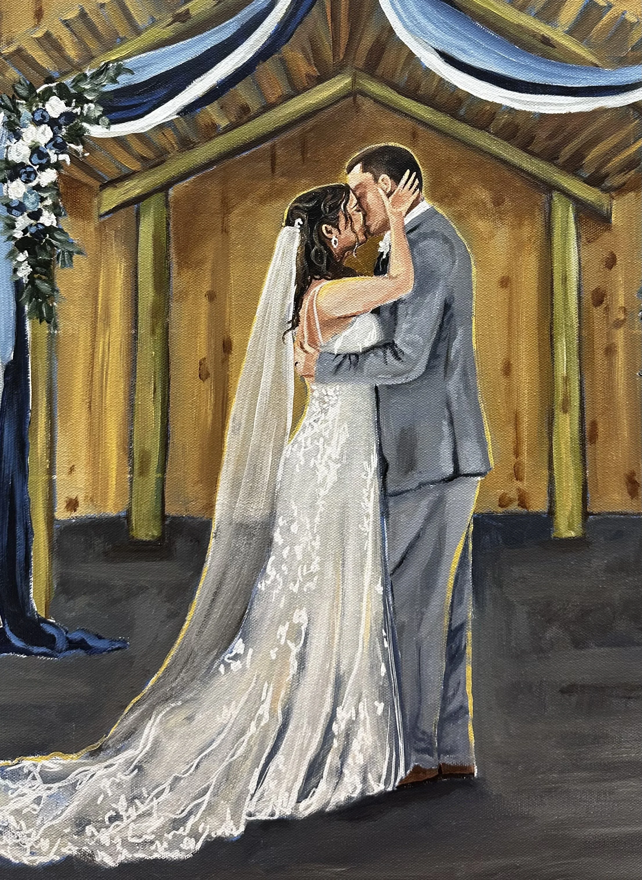 A bride and groom sharing a kiss at their wedding ceremony on a wooden altar adorned with flowers and blue drapery.