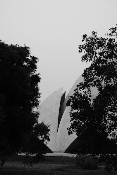 Lotus Temple through the fence and trees