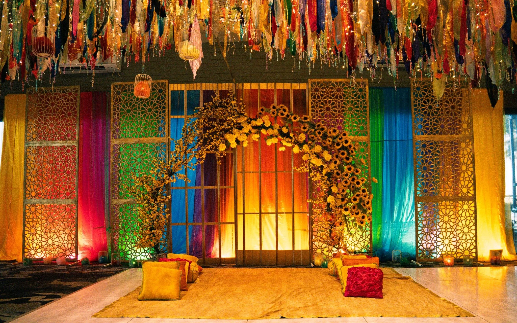 This Sangeet setup is where vibrant colour meets intentional design.
From the layered backdrops to the floral installations and overhead detailing, every element is placed to shape the energy of the night.
Designed for celebrations that feel as good 
