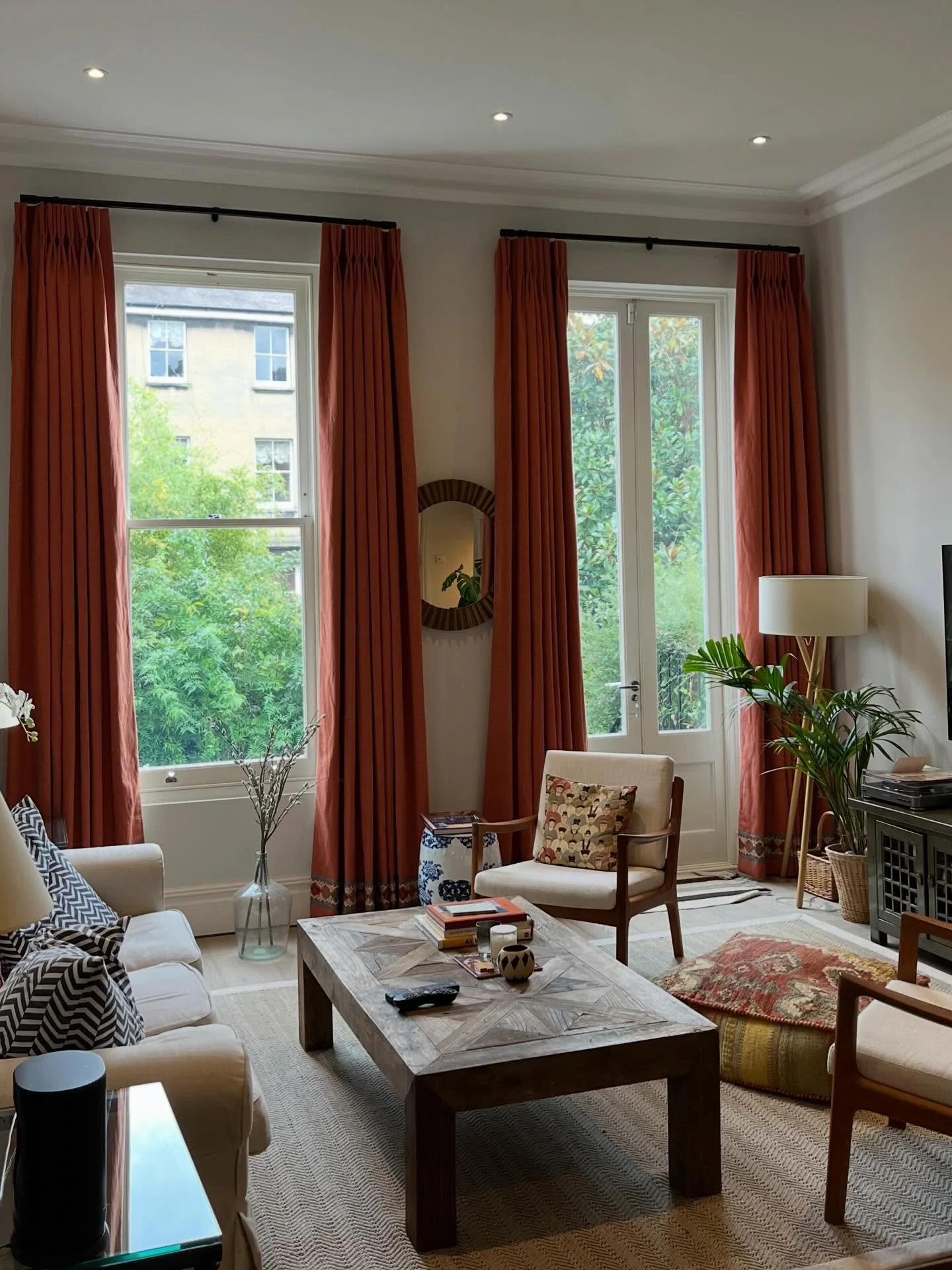 Swipe to see how much these curtains changed the room &rarr;

The original sheers felt cold and a bit lifeless.
The space needed warmth; especially in the evenings.

We introduced a rich terracotta linen, added a trim detail,
and raised the height to