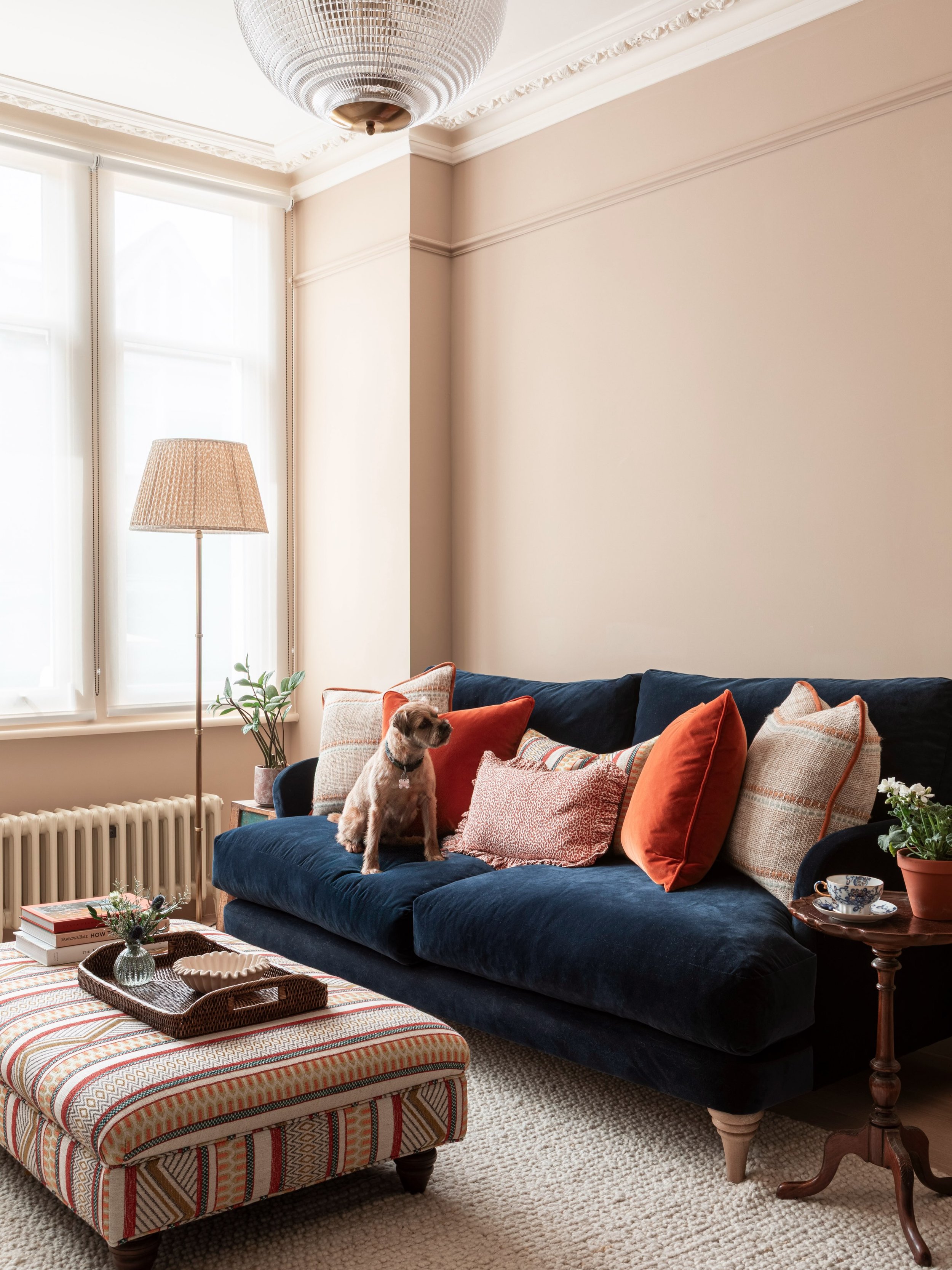 When we finished this drawing room in Barnes, @michael.branthwaite photographed it beautifully - that navy sofa, the rust and terracotta cushions, a simple roller blind doing the job at the window. We loved it as it was, but we always knew curtains a