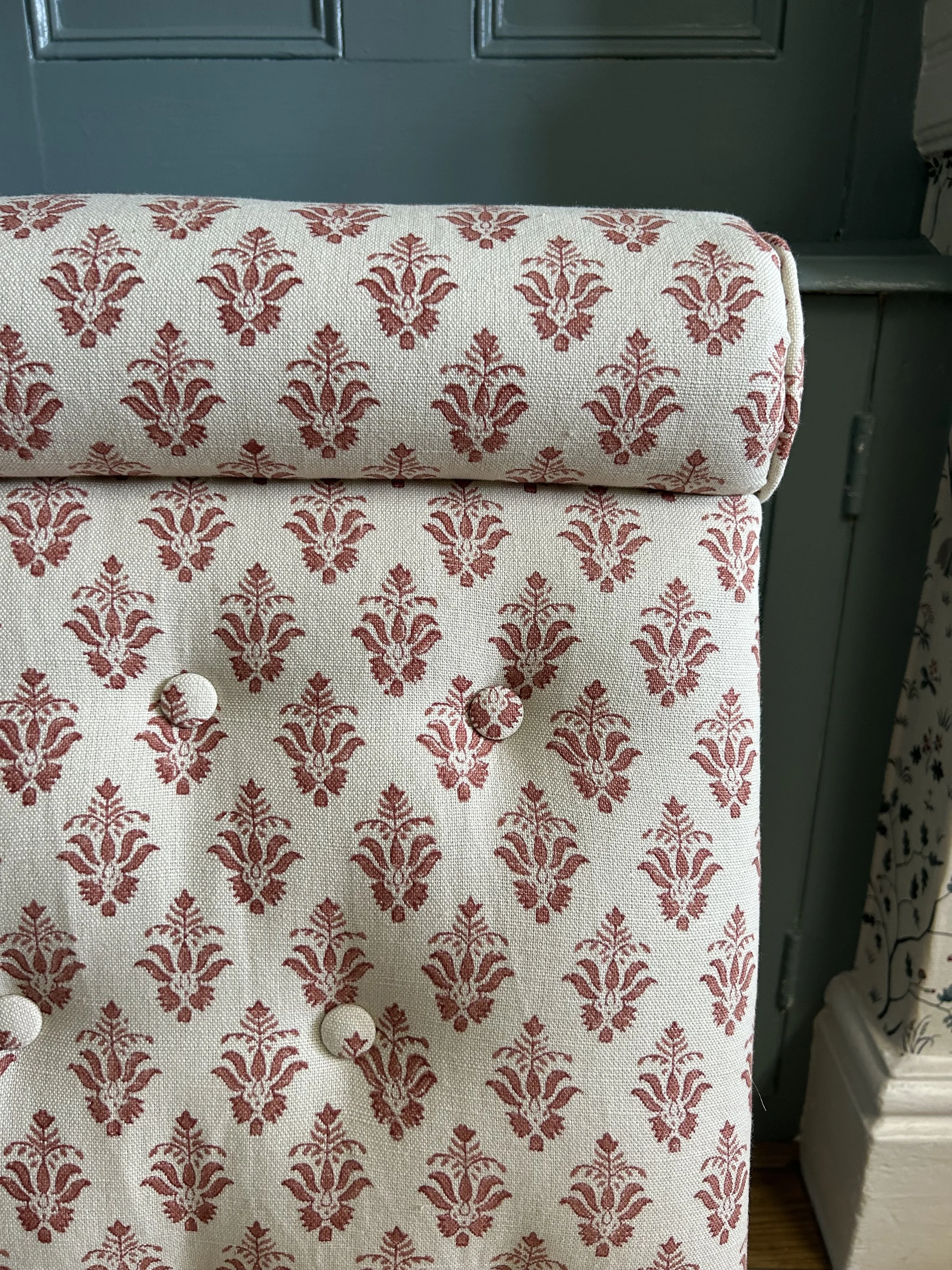 Buttoned seat and bolster in a red and cream print by GP & J Baker