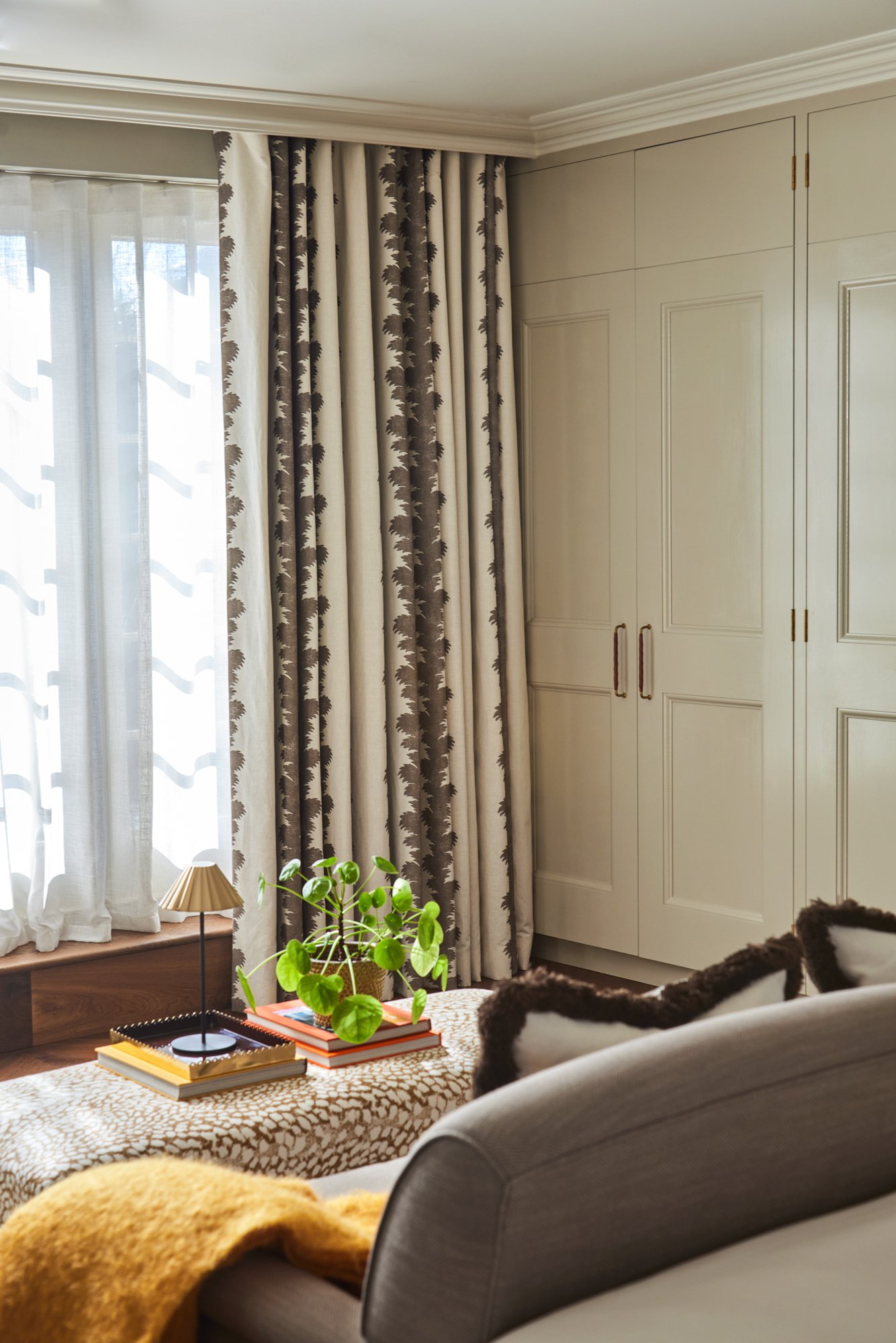 Printed linen curtains layered over sheer voiles in a principal bedroom