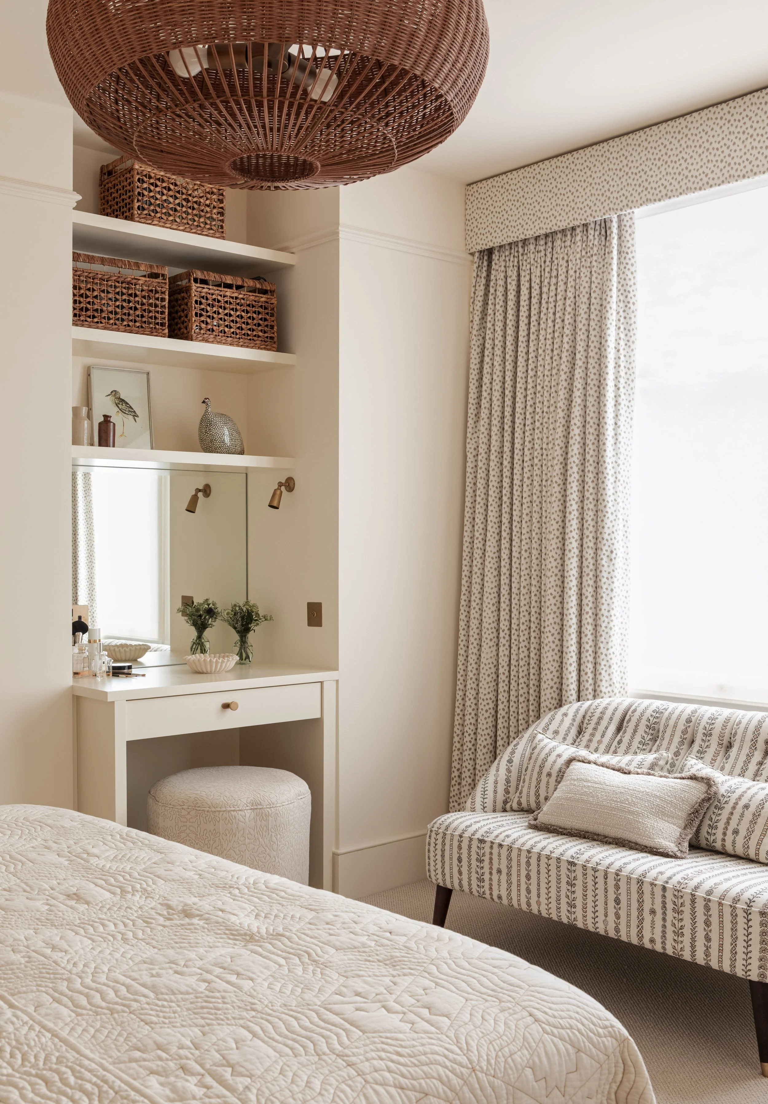 Bedroom curtains with a matching upholstered pelmet in a neutral spot print