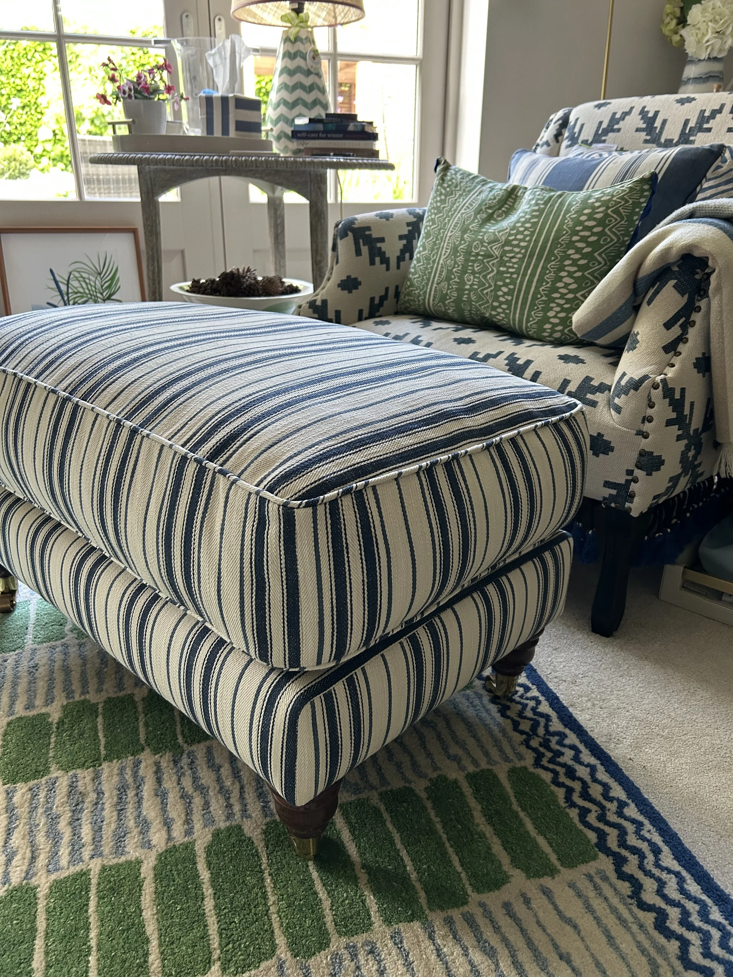 Footstool in a navy and cream stripe by Ralph Lauren, with piped edges
