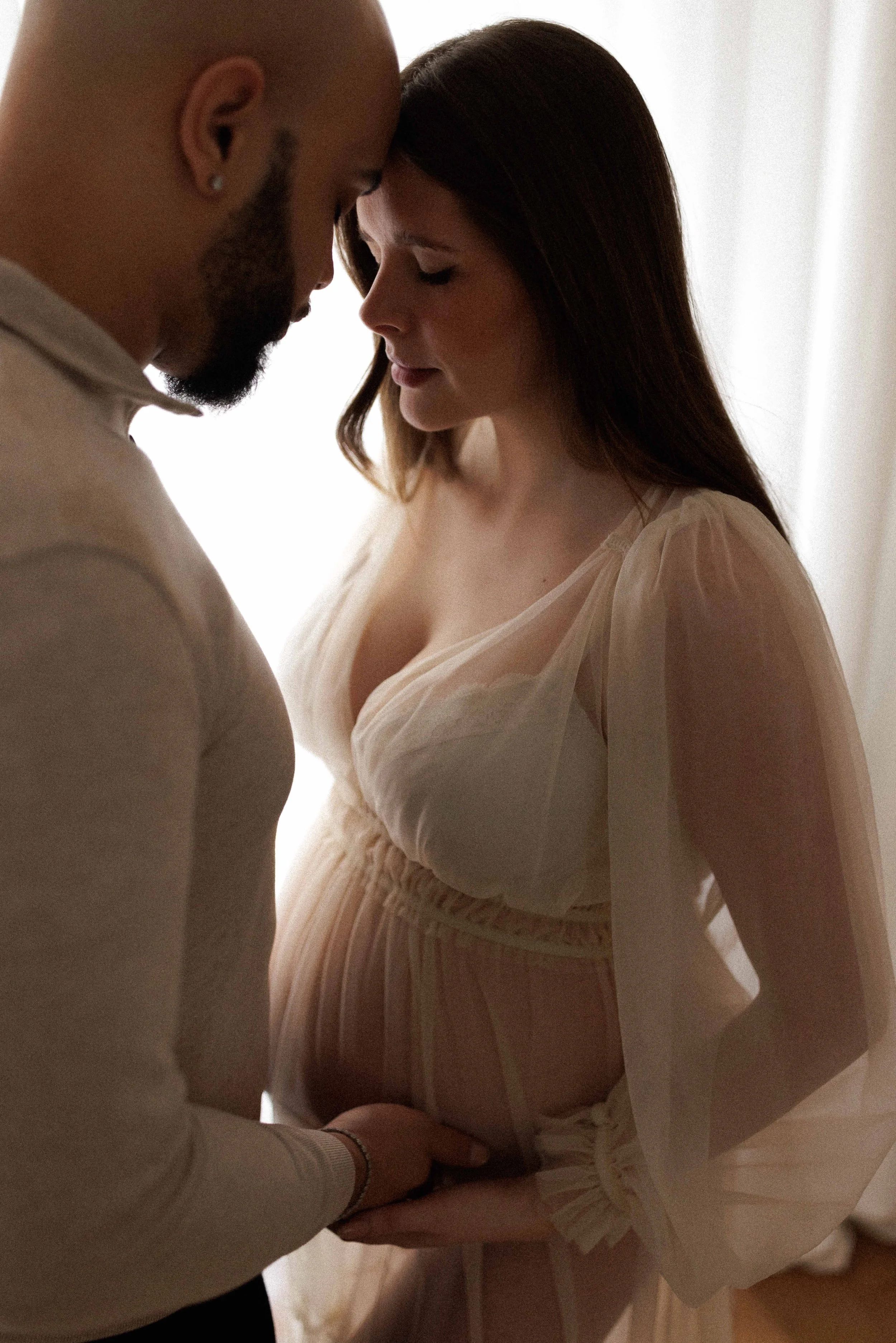 pregnant mum and partner hugging each other in a photography studio in warlingham surrey