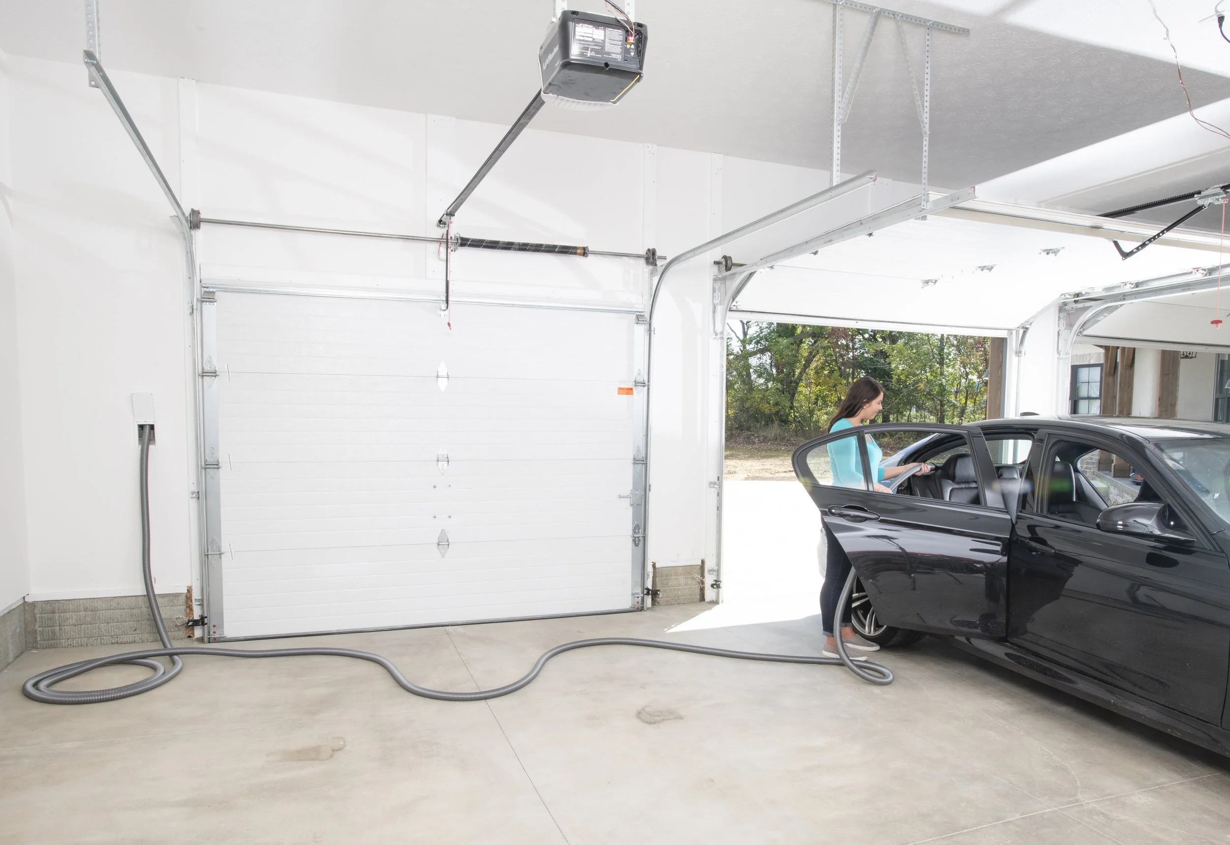 Cleaning a car using a retractable central vacuum hose