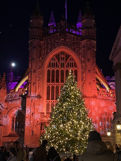 People holding and petting lambs indoors, smiling and interacting with the animals.